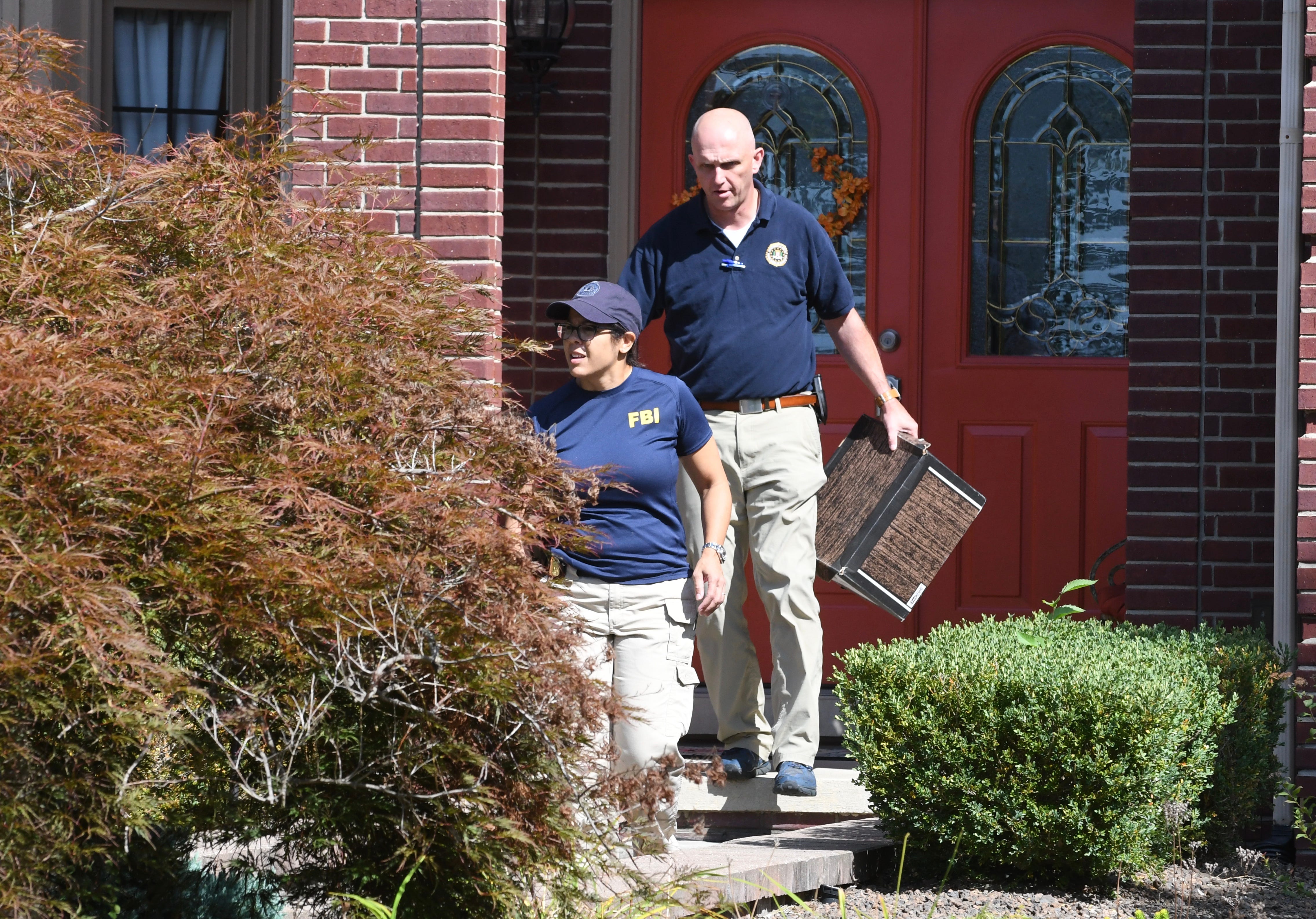 FBI investigators leave the home of UAW President Gary Jones after a search Wednesday in Canton.