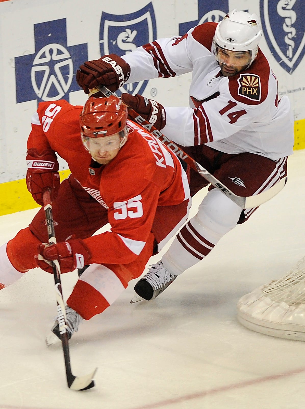 Red Wings ' Niklas Kronwall works the puck around the net with Coyotes ' Nigel Dawes defending during a game at Joe Louis Arena on March 10, 2009.