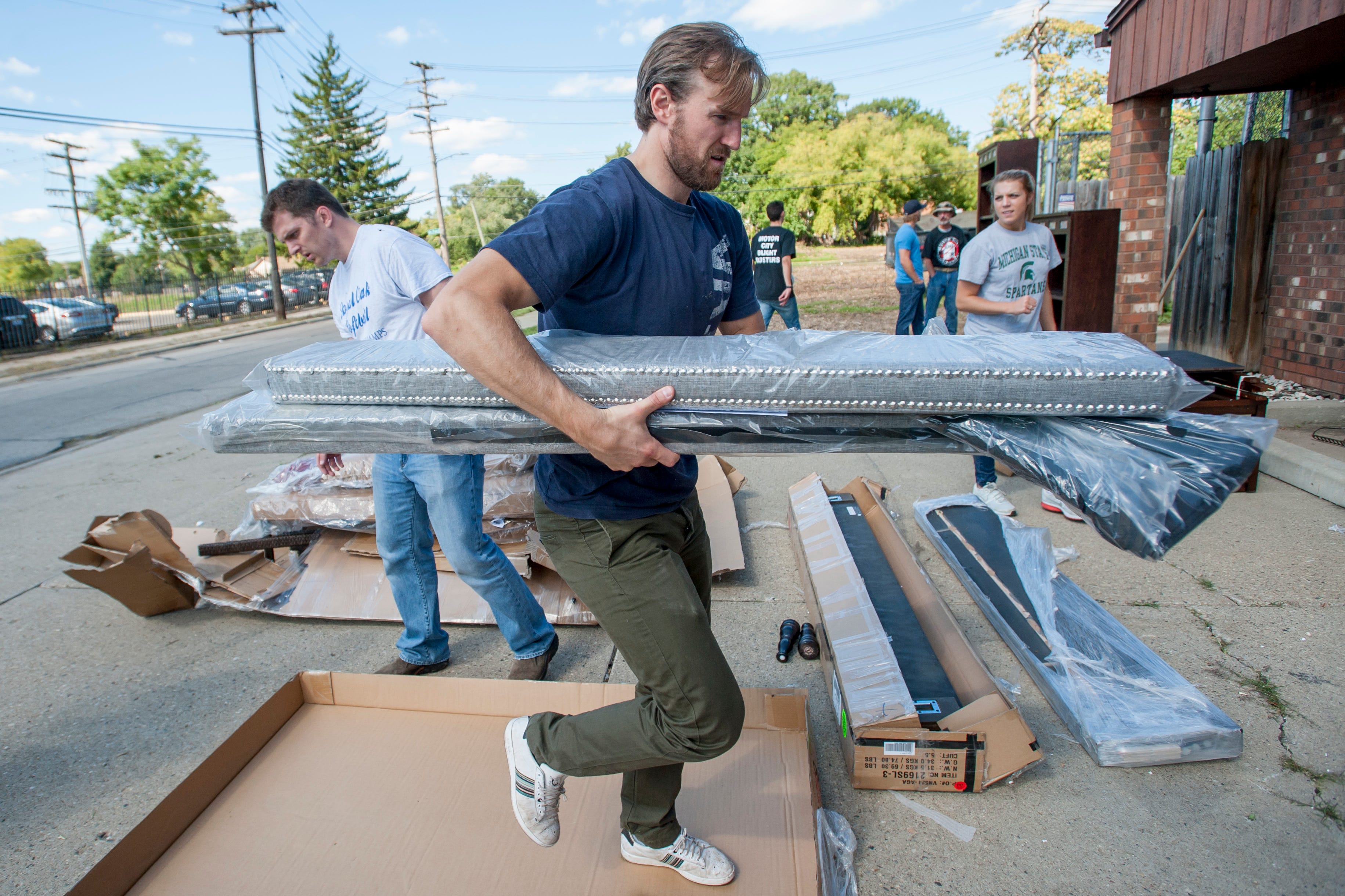 Red Wings defenseman Niklas Kronwall helps move furniture while volunteering with the Motor City Blight Busters in Detroit on Sept. 16, 2014.