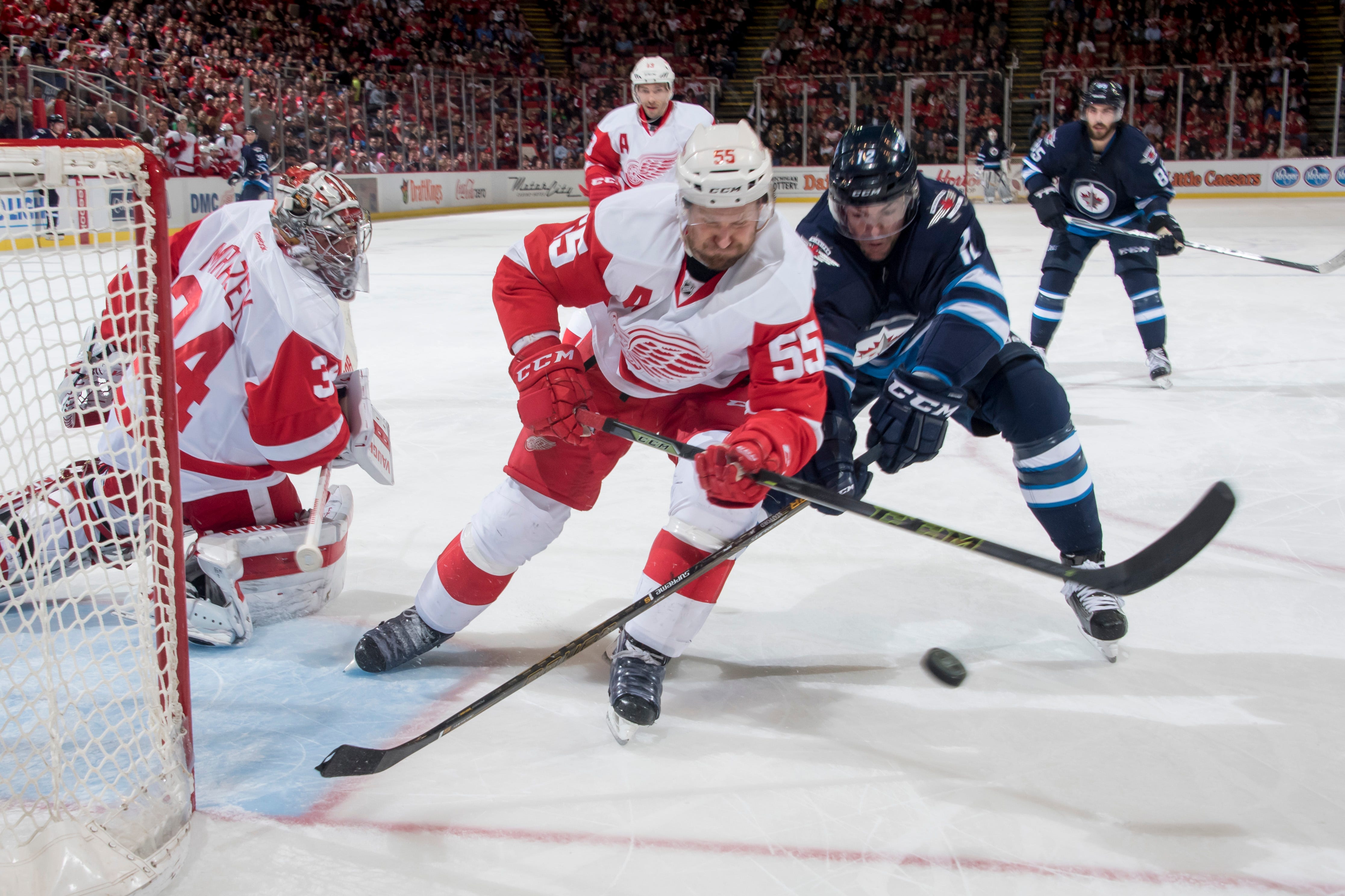 Detroit defenseman Niklas Kronwall and Winnipeg right wing Drew Stafford battle for the puck in front of Detroit goalie Petr Mrazek during a game at Joe Louis Arena on March 10, 2016.
