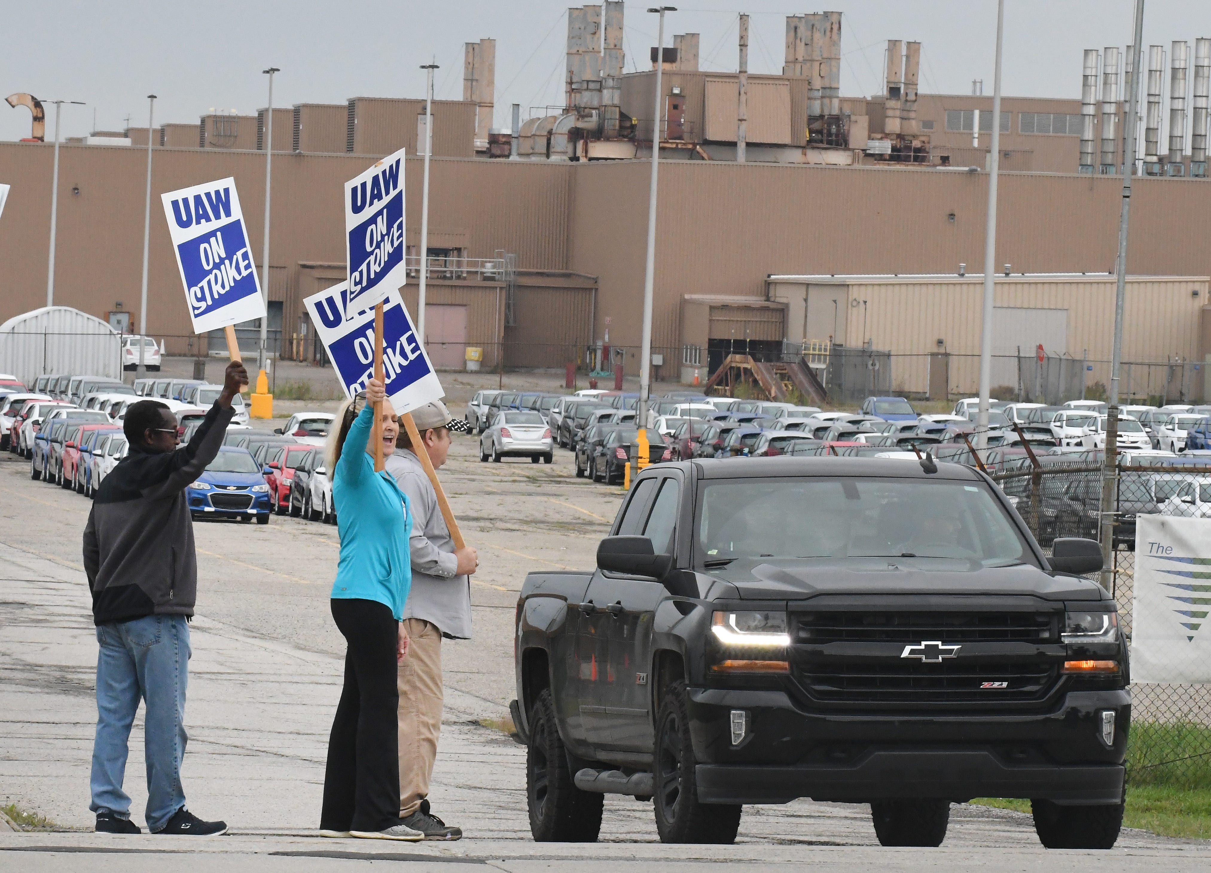 Debbie Gibson and other UAW workers react as a car honks for picketers on the south side of the GM Lake Orion Assembly plant in Lake Orion, Michigan, early Monday, Sept. 16, 2019.