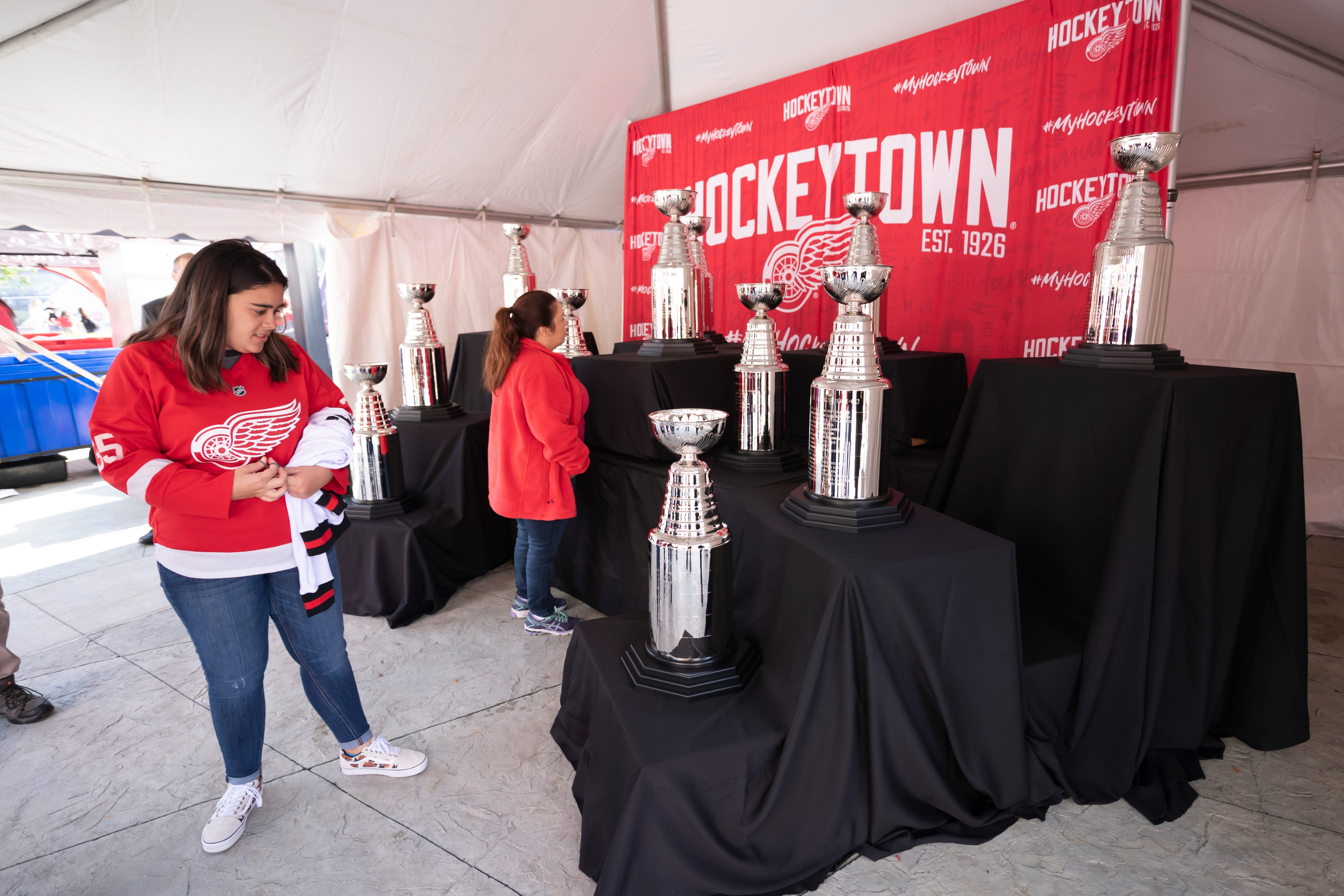 Fans check out miniature replicas of the 10 Stanley Cups the Red Wings have won during the team ' s history. David Guralnick, Detroit News