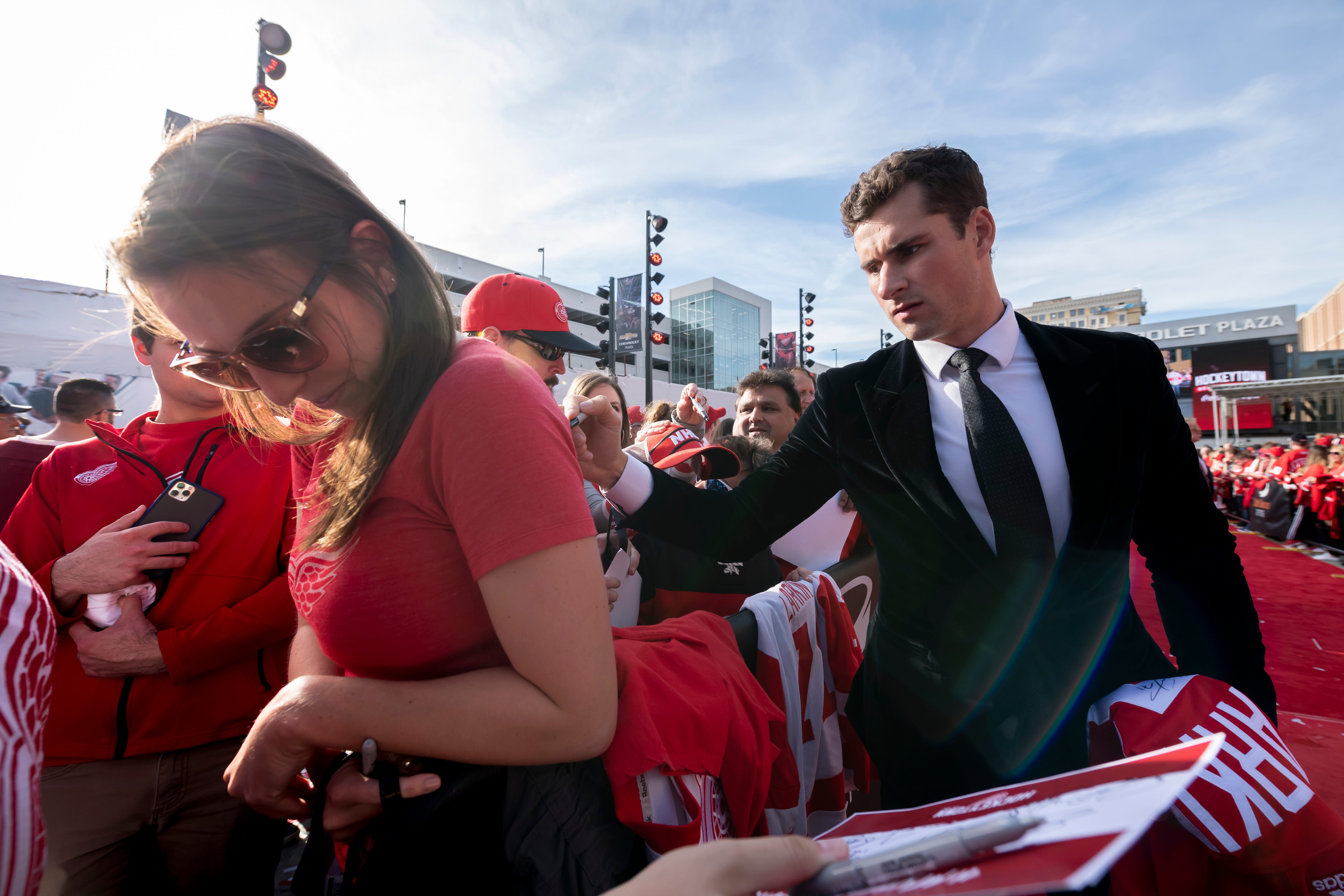 Red Wing Dylan Larkin signs the shirt of Ashley Felcyn, of Oxford, during a red carpet ceremony before the team's home opener against the Dallas Stars.