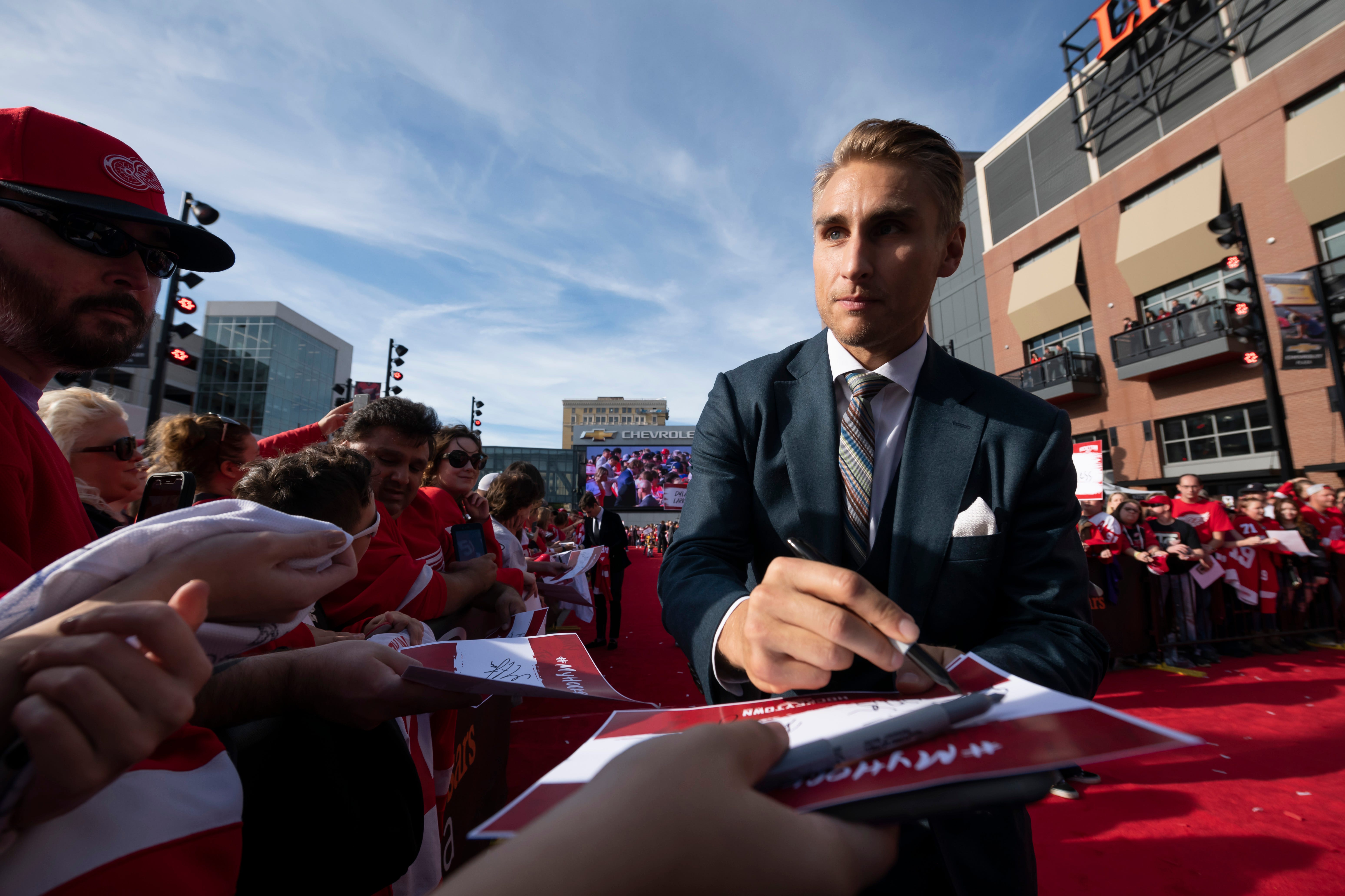 Red Wing Valtteri Filppula signs autographs while participating in a red carpet ceremony before the team's home opener against the Dallas Stars at Little Caesars Arena, in Detroit, October 6, 2019.