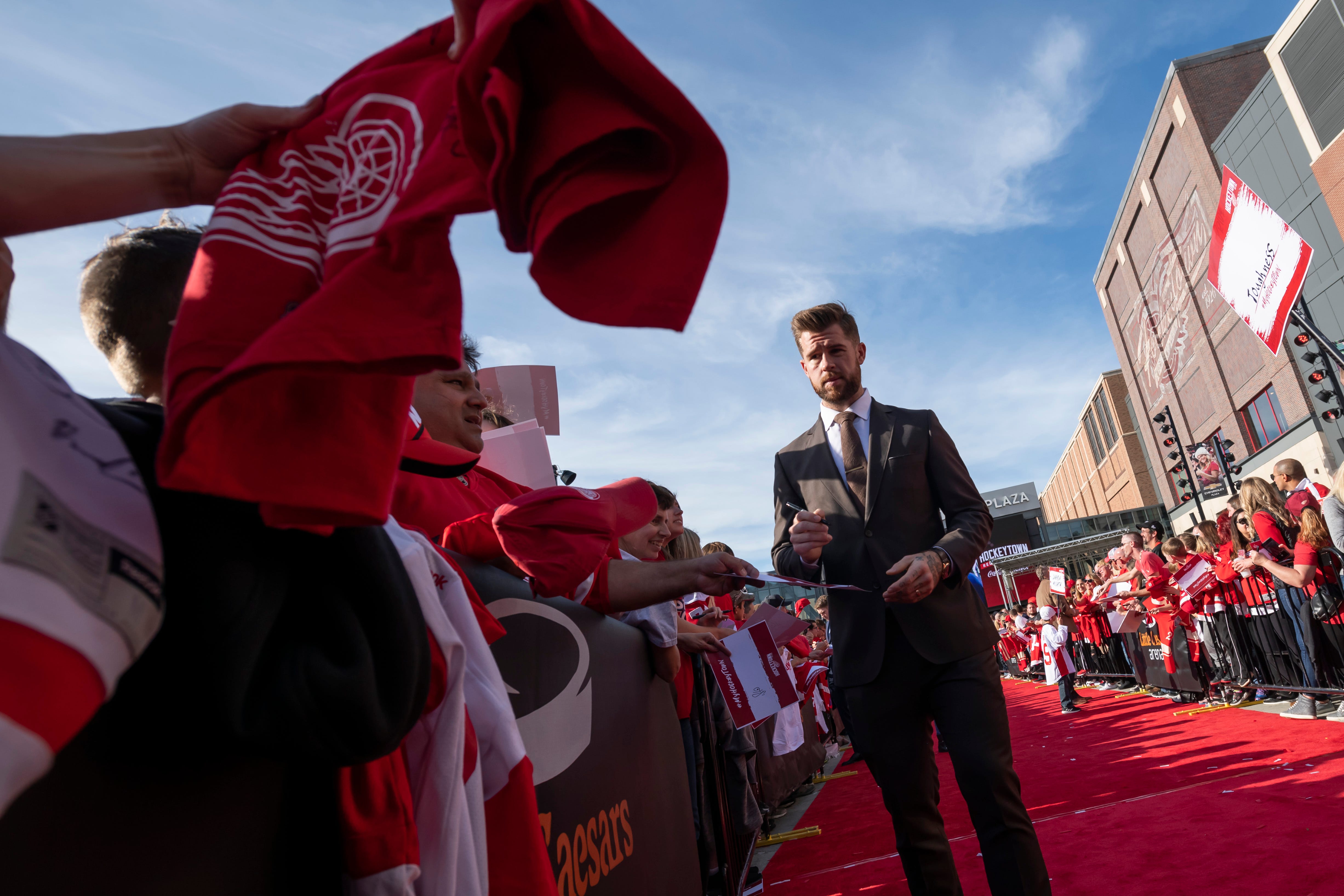 Red Wing Mike Green signs autographs while participating in a red carpet ceremony before the team's home opener against the Dallas Stars.