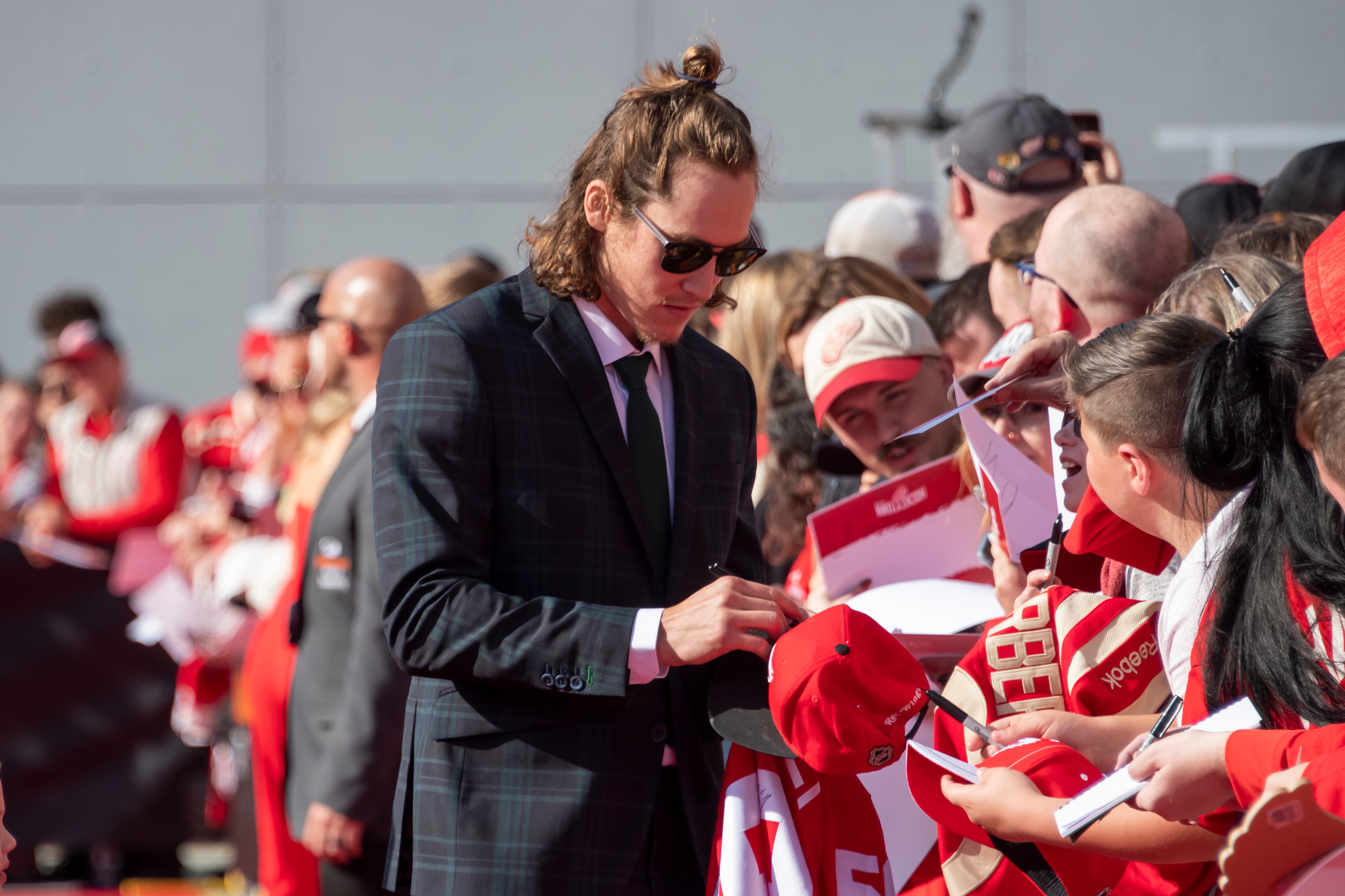 Detroit left wing Tyler Bertuzzi signs autographs while participating in a red carpet ceremony before the team's home opener against the Dallas Stars.