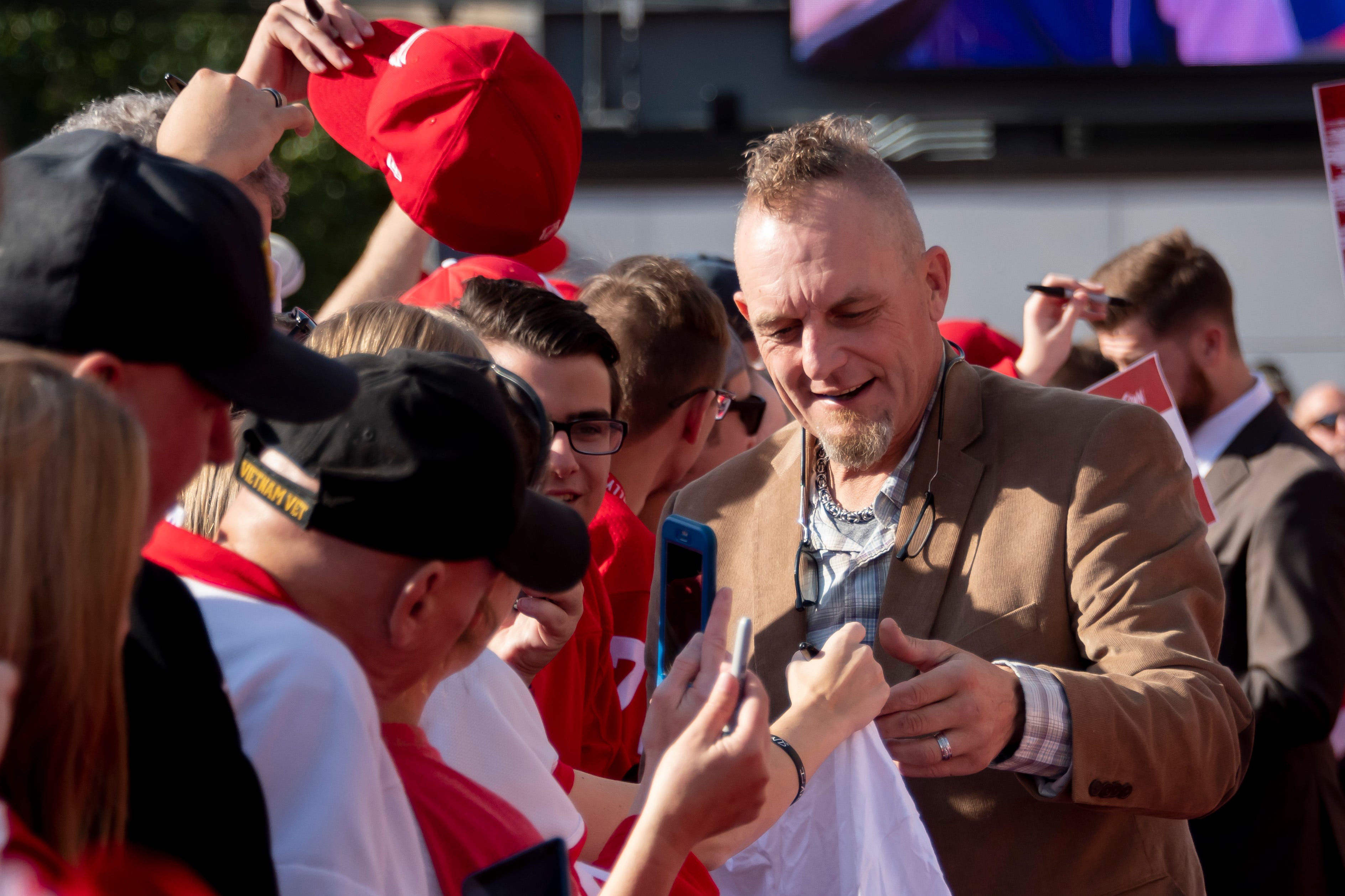 Former Red Wing Darren McCarty signs autographs while participating in a red carpet ceremony before the team's home opener against the Dallas Stars.