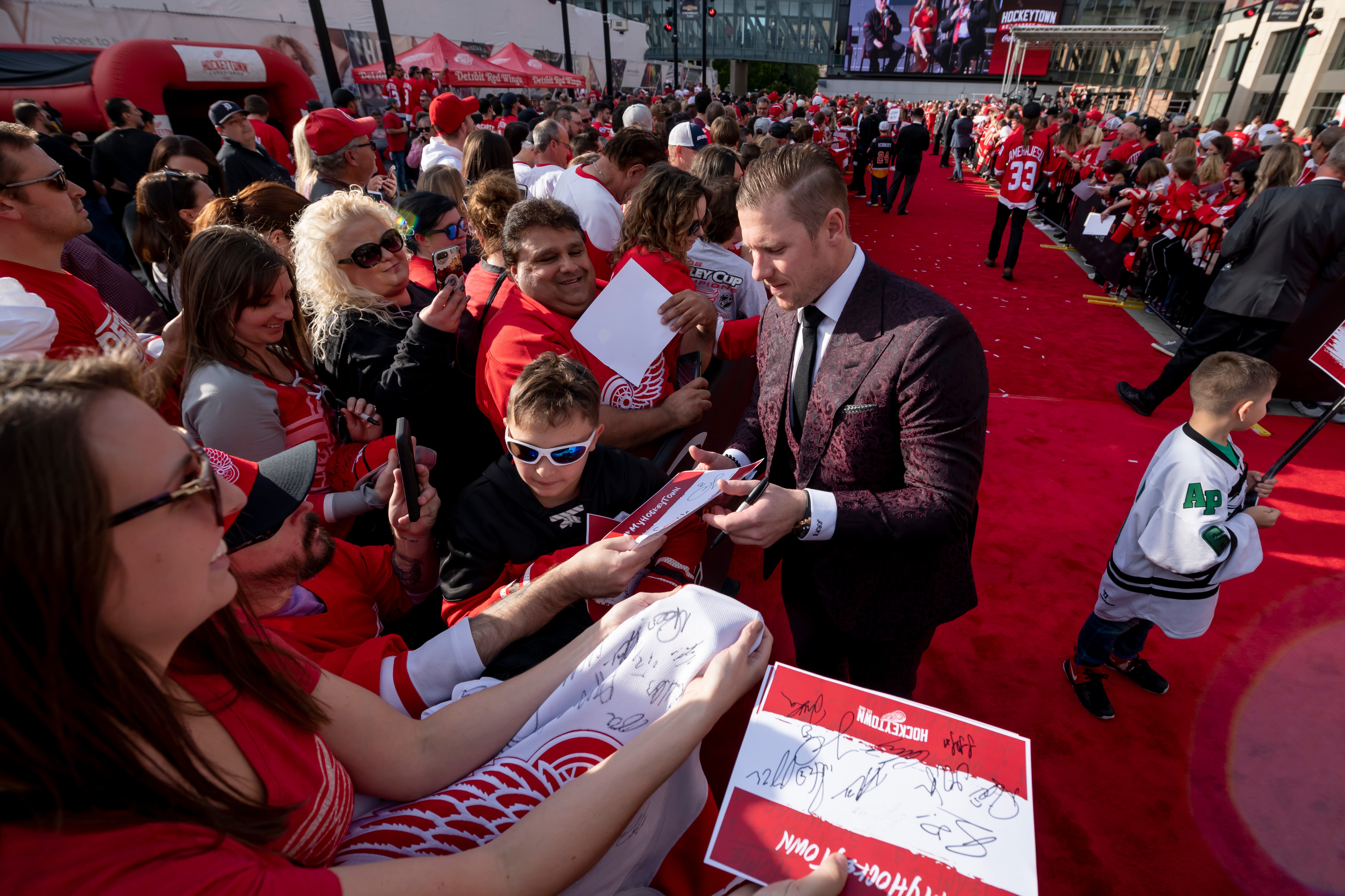 Red Wings goaltender Jimmy Howard signs autographs while participating in a red carpet ceremony before the team's home opener against the Dallas Stars.