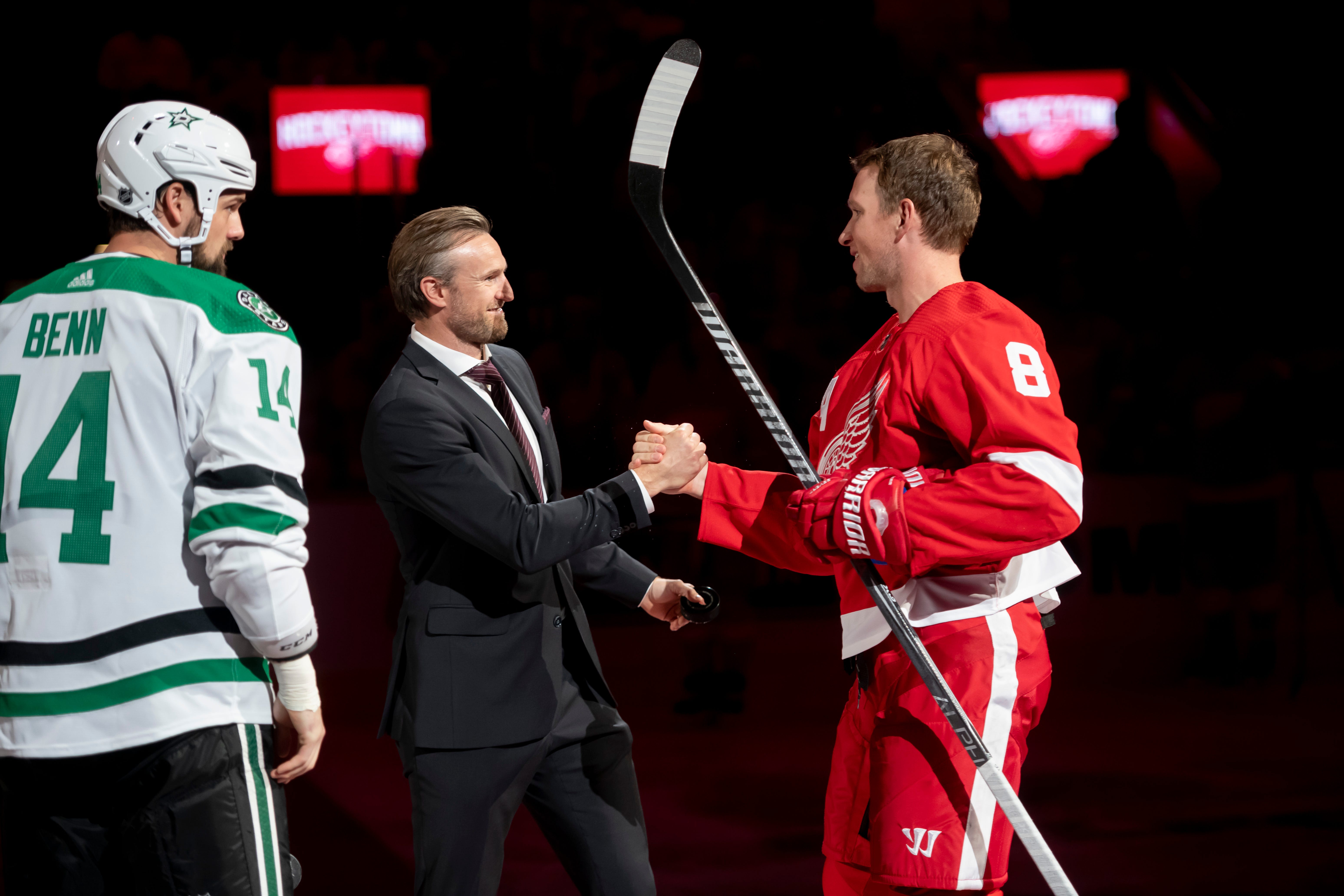 Former Red Wings defenseman Nicklas Kronwall shakes hands with Detroit left wing Justin Abdelkader after a ceremonial puck drop before the start of the game.