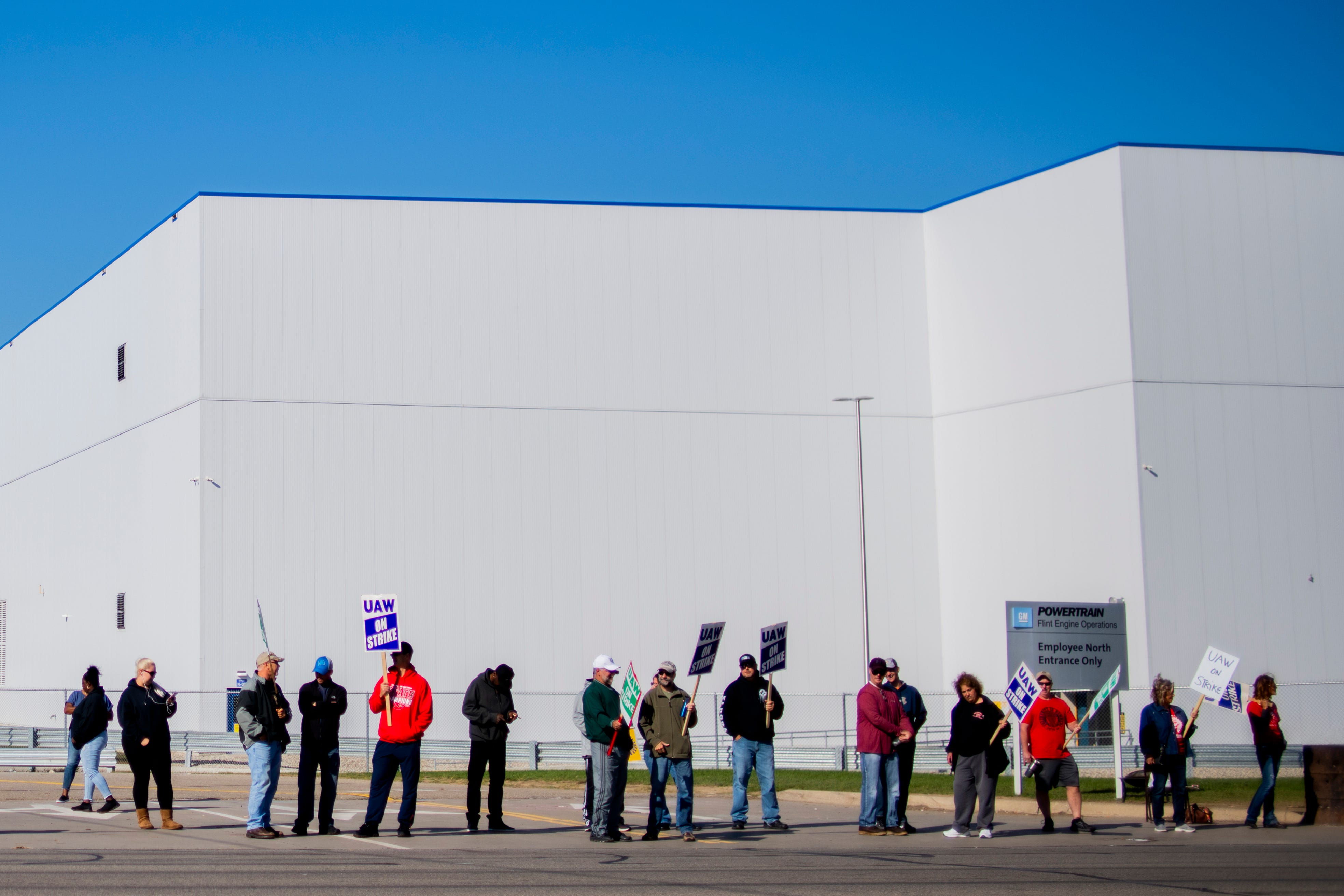 General Motors' Flint Assembly Plant employees line the street with picket signs in Flint on Monday.