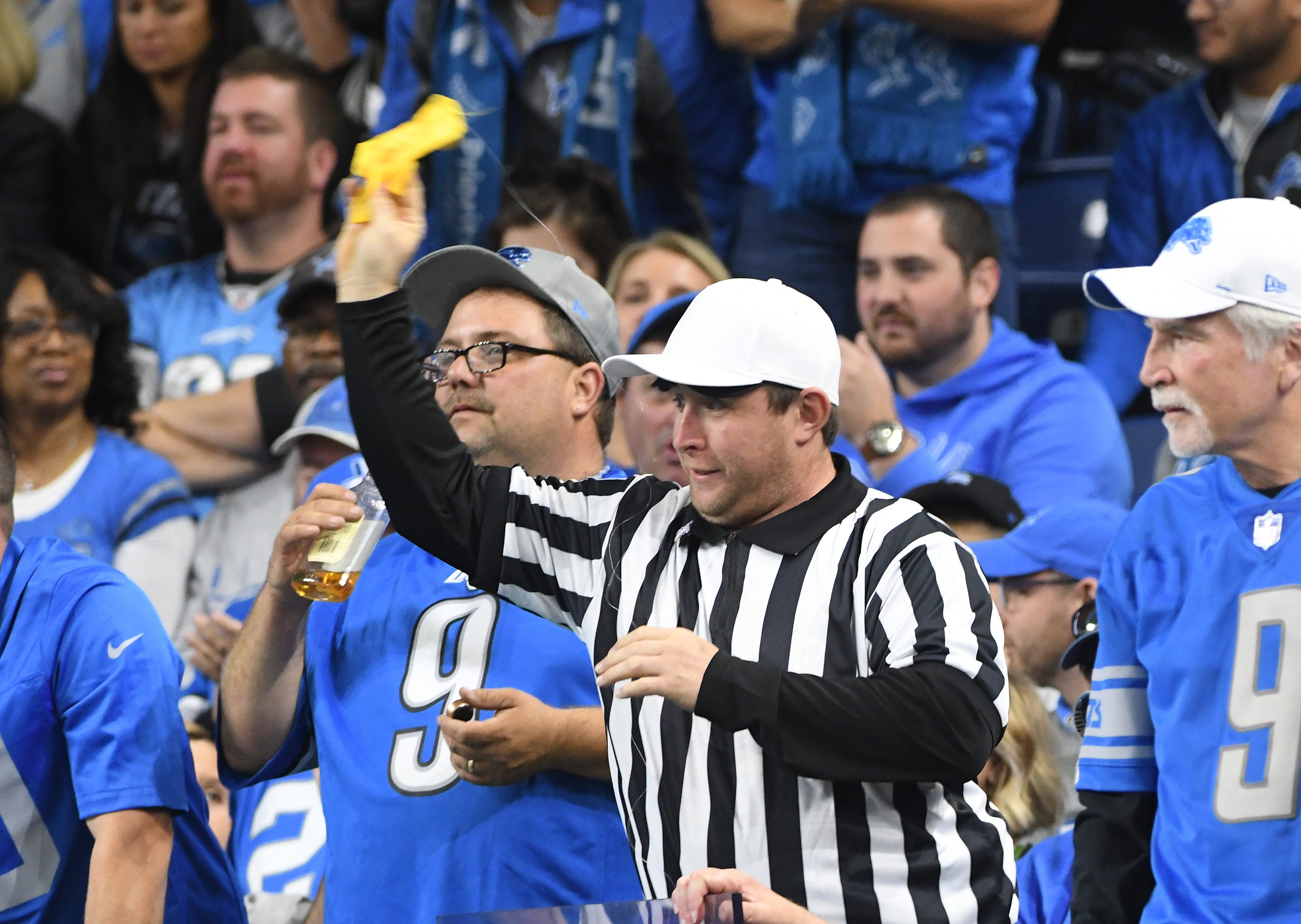 A fan in the stands dressed as a referee throws the yellow flag. But unlike real officials, he has a string attached so that he can pull it back off the field.