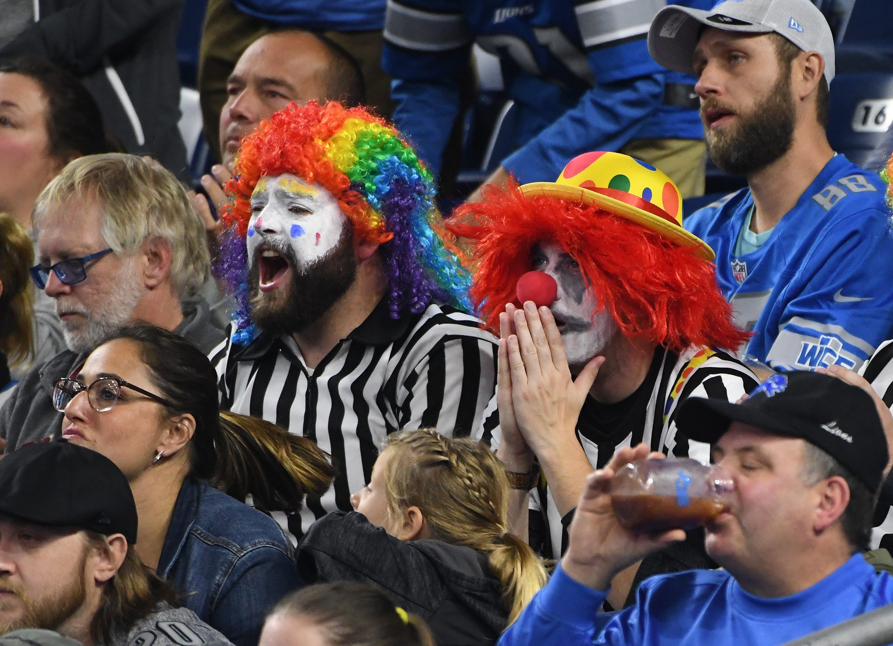 Fans dressed in referee clown outfits sit quietly as the Vikings slowly take down the Lions in a 42-30 loss at Ford Field.