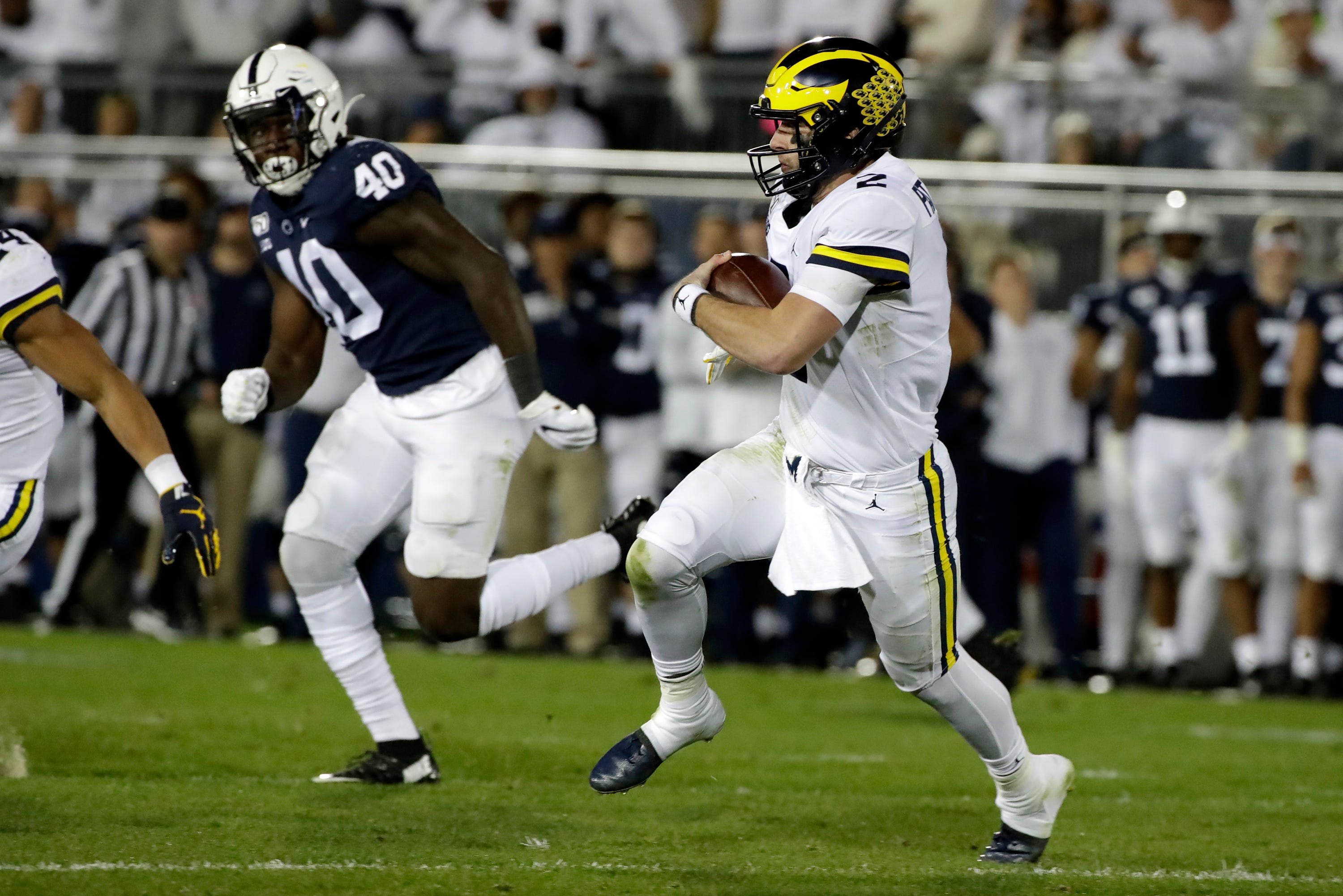 Michigan quarterback Shea Patterson, right, runs for a first down during the first half.