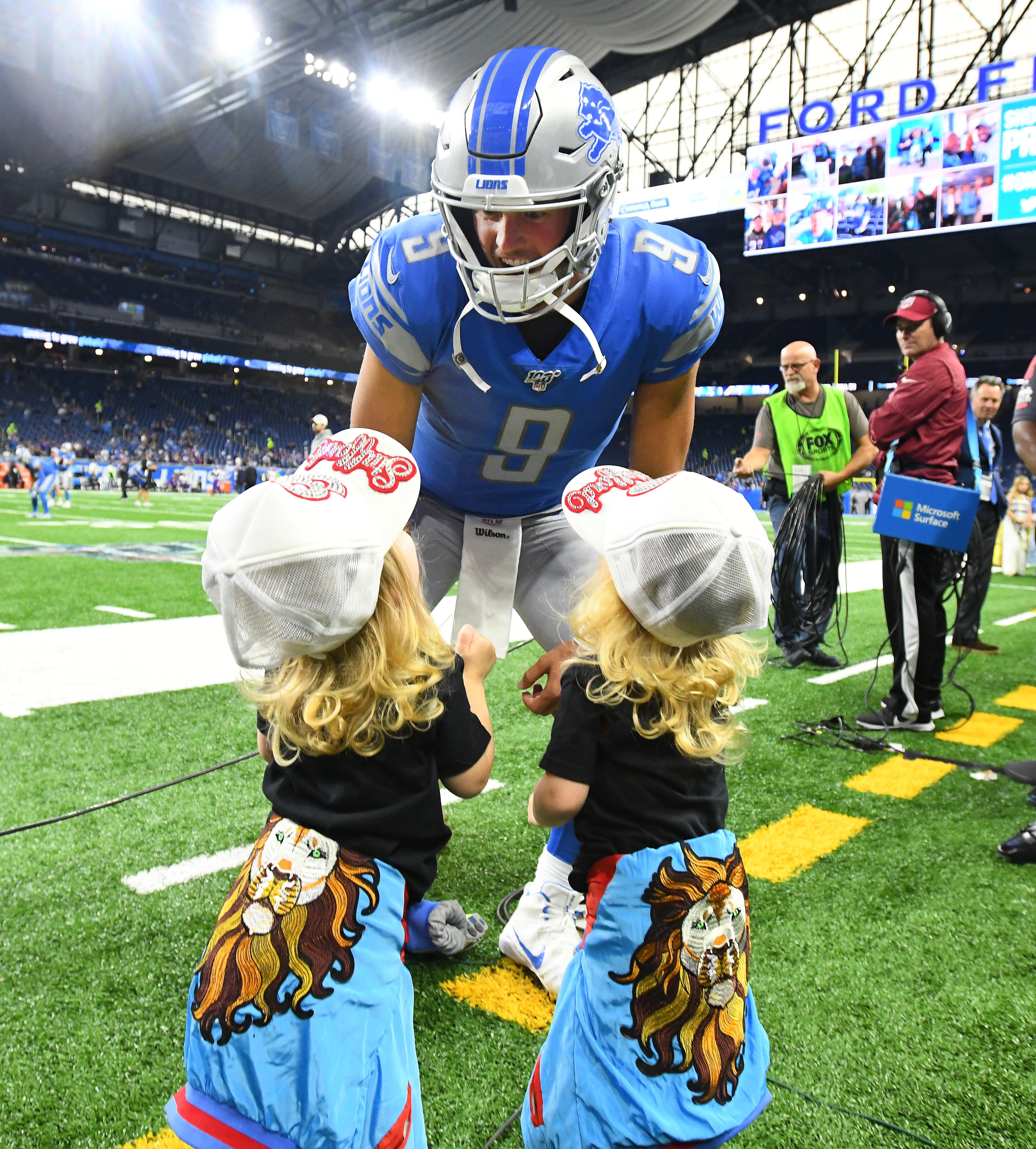 Lions quarterback Matthew Stafford visits with his twin daughters Sawyer and Chandler on the sidelines before Sunday ' s game.