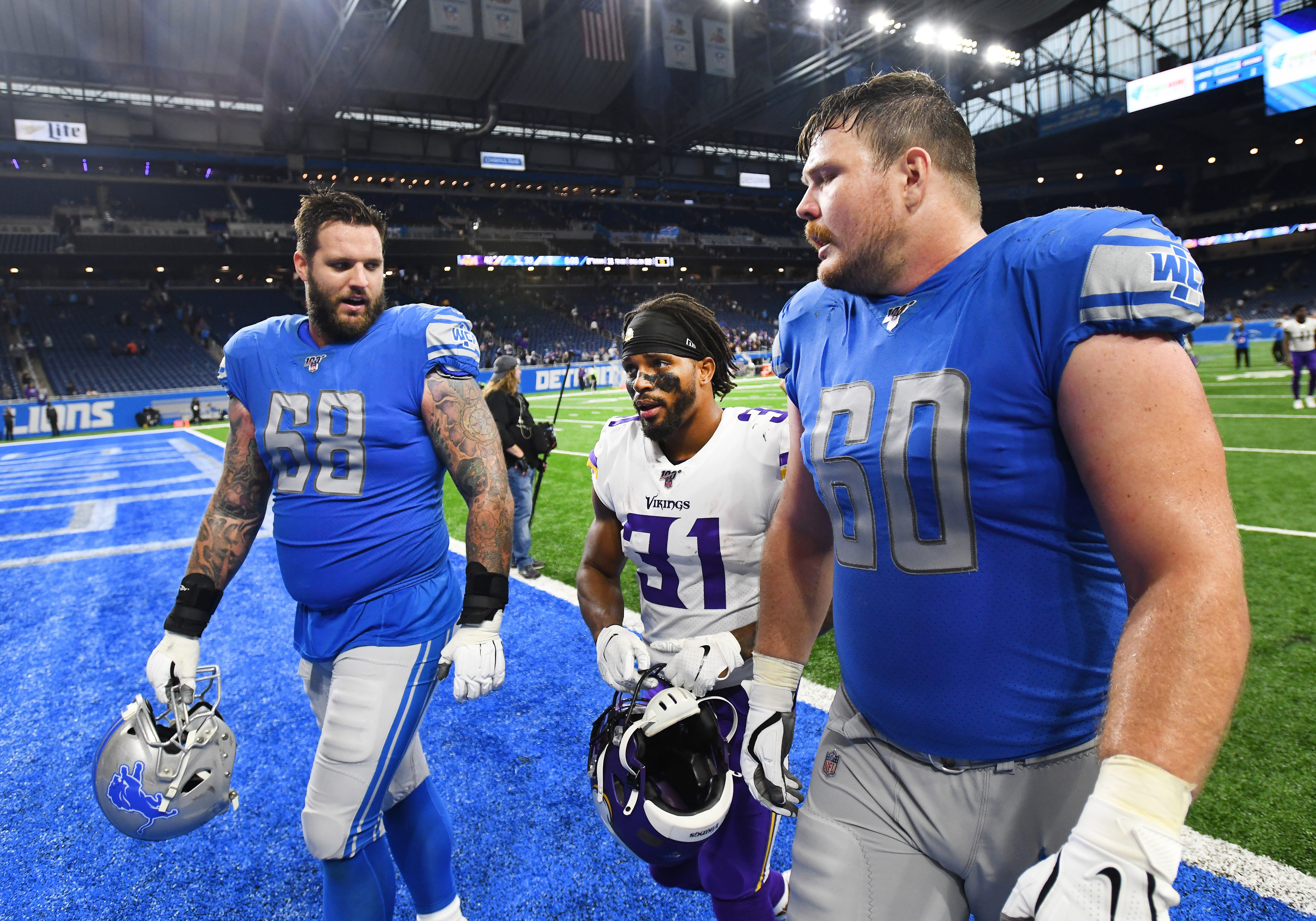 Lions ' Taylor Decker and Graham Glasgow walk with former Lion and Vikings special teams player Ameer Abdullah after the game.