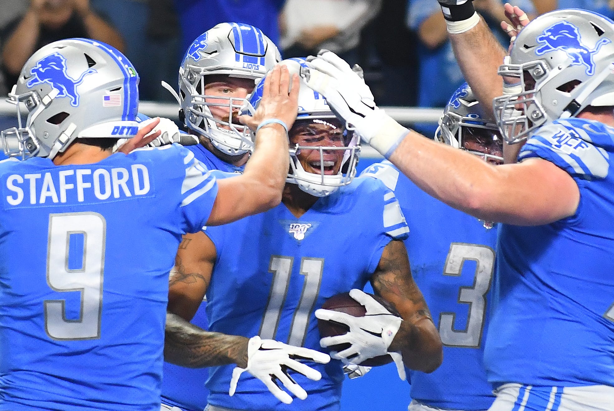 Lions' Marvin Jones celebrates with teammates Matthew Stafford and Frank Ragnow after his third touchdown reception in the second quarter.