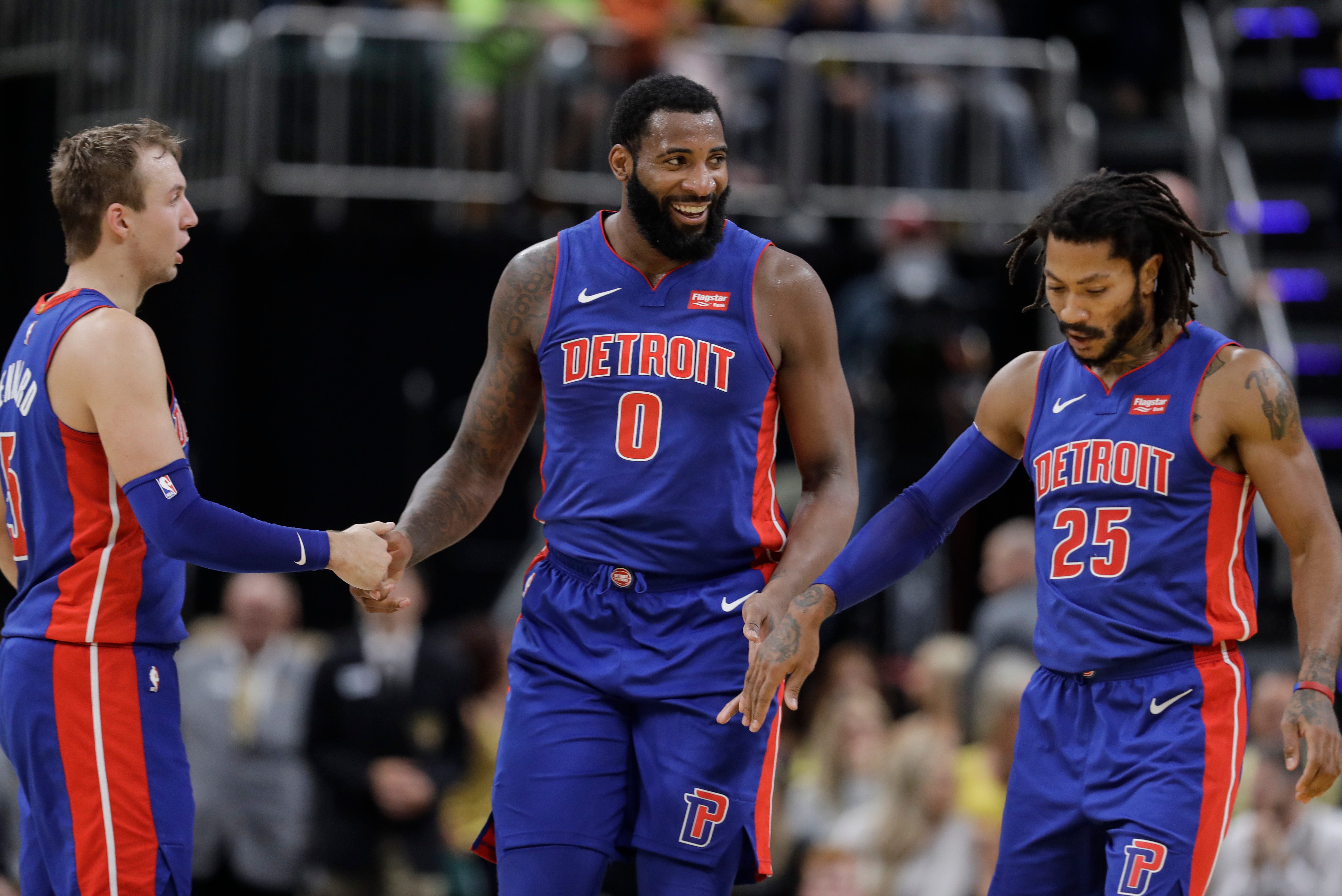 Detroit Pistons ' Andre Drummond (0) reacts with Luke Kennard, left, and Derrick Rose, right, during the second half of Wednesday ' s 119-110 win in the season opener.