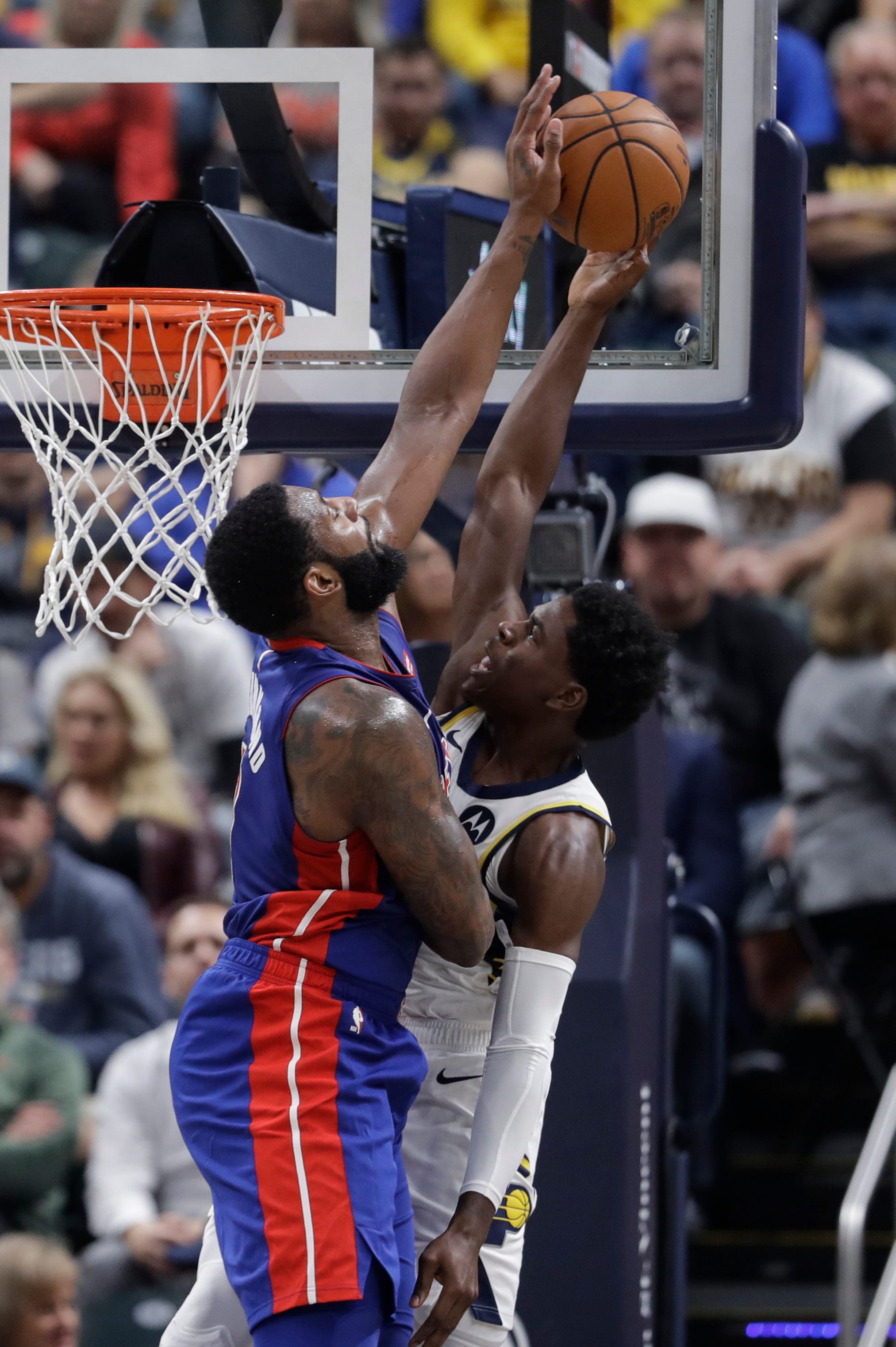 Indiana Pacers' Aaron Holiday, right, has his shot blocked by Detroit Pistons' Andre Drummond during the first half.