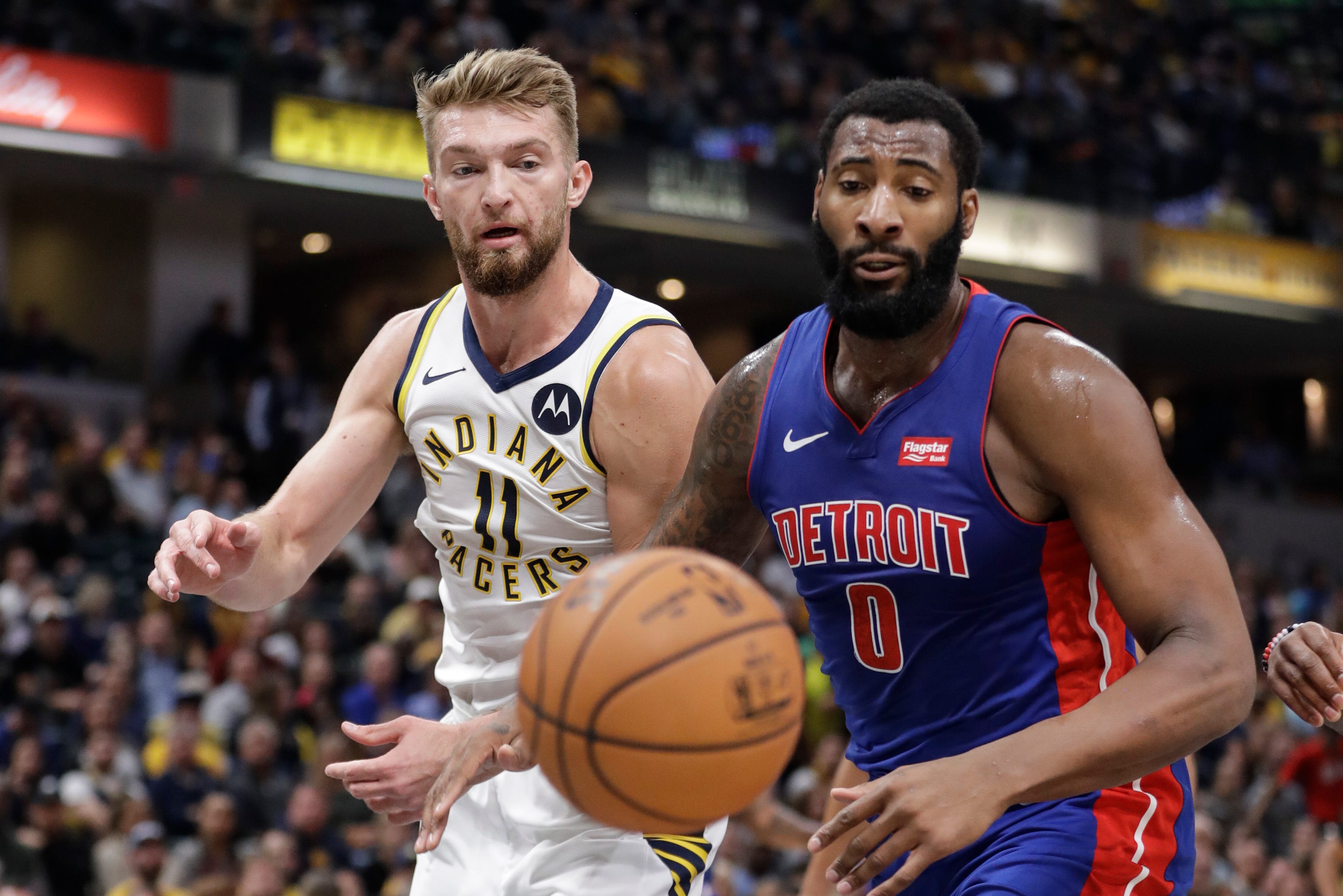 Indiana Pacers' Domantas Sabonis (11) and Detroit Pistons' Andre Drummond (0) eye a loose ball during the first half.