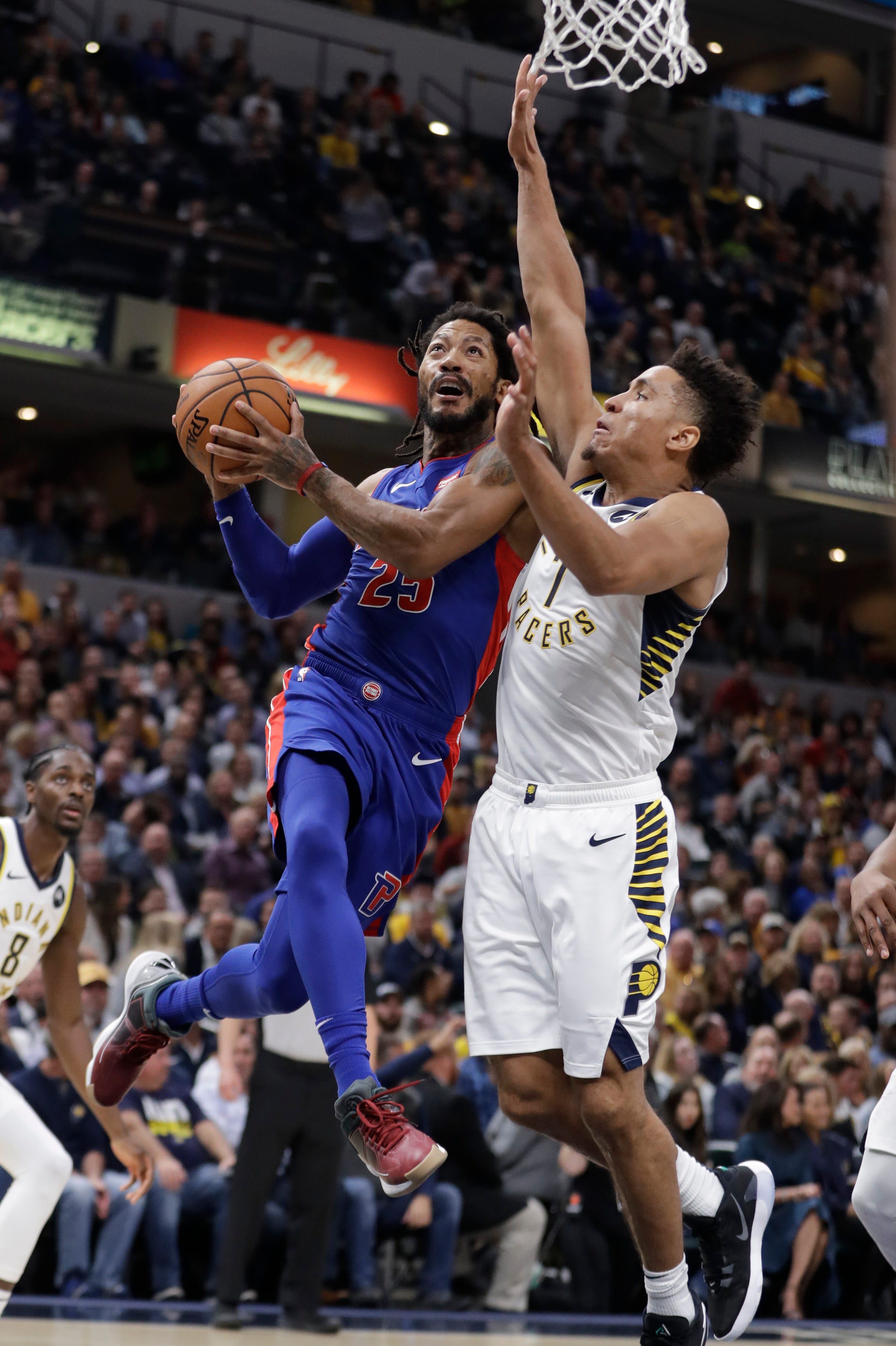 Detroit Pistons ' Derrick Rose, left, puts up a shot next to Indiana Pacers ' Malcolm Brogdon during the first half.
