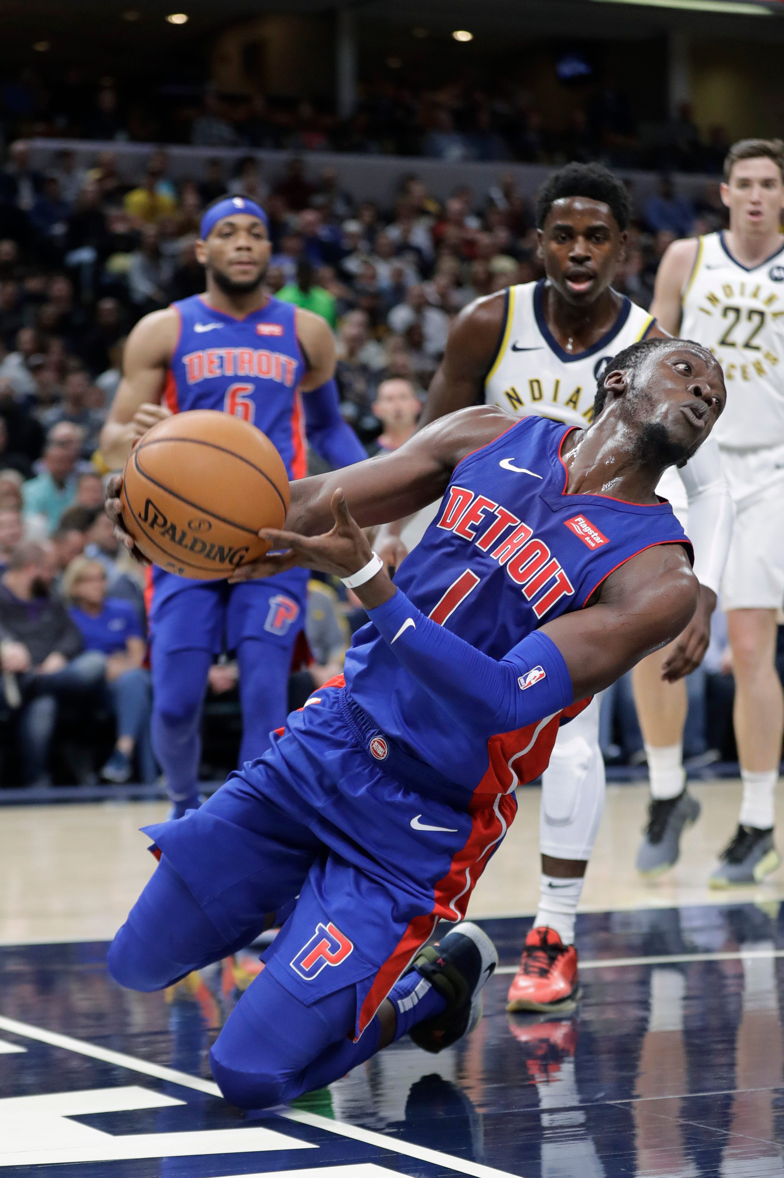 Detroit Pistons ' Reggie Jackson (1) saves the ball from going out of bounds during the first half.