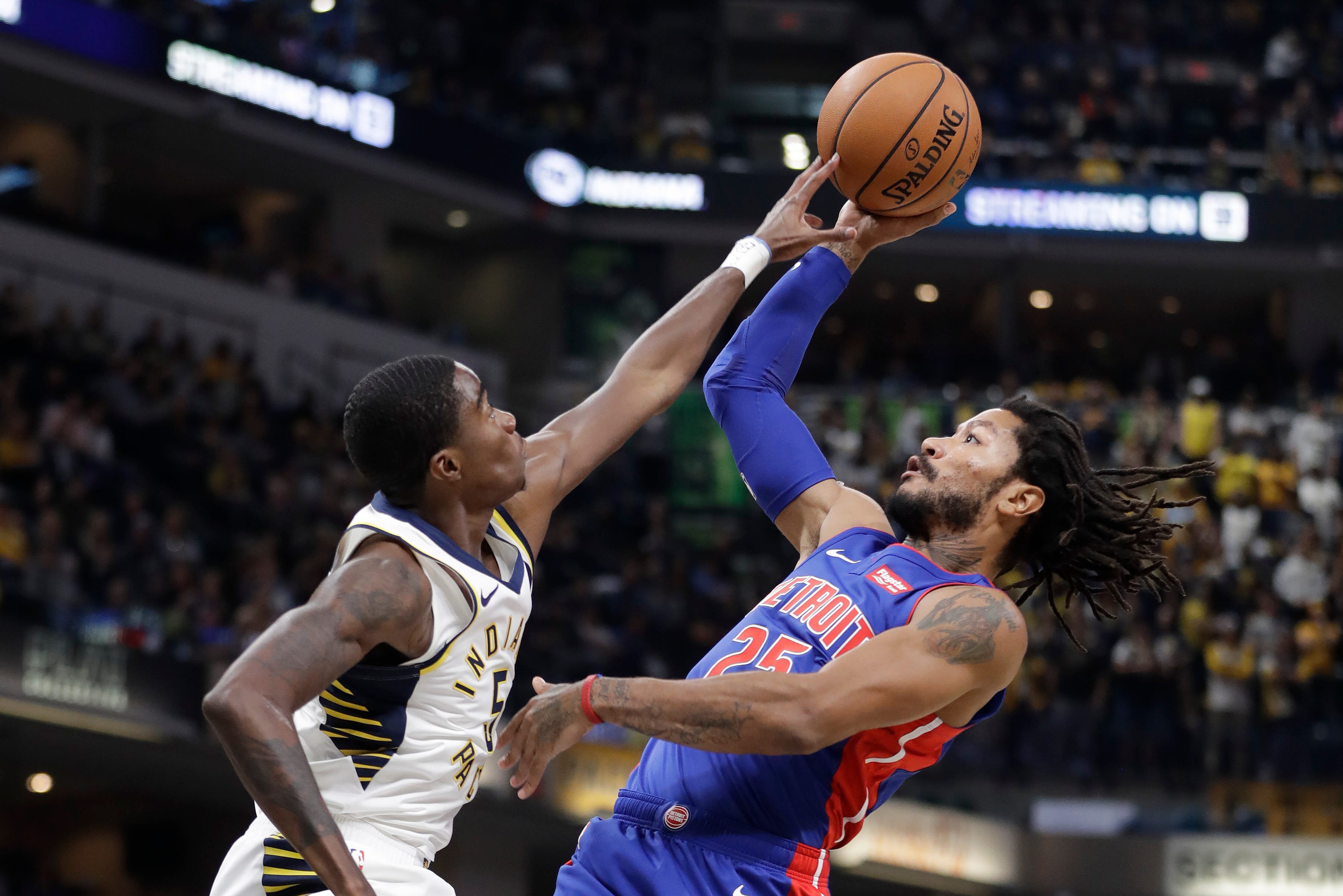 Detroit Pistons ' Derrick Rose, right, is fouled by Indiana Pacers ' Edmond Sumner as he goes up for a shot during the first half.