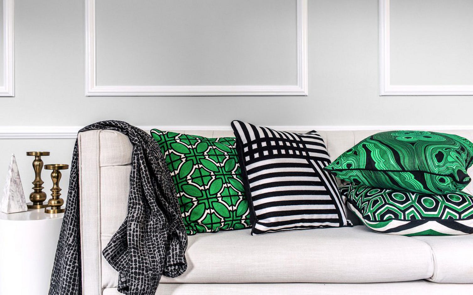 Products from Natale's accessories line include throws (textured black and white) and pillows (printed in geometric, striped, marbled patterns).