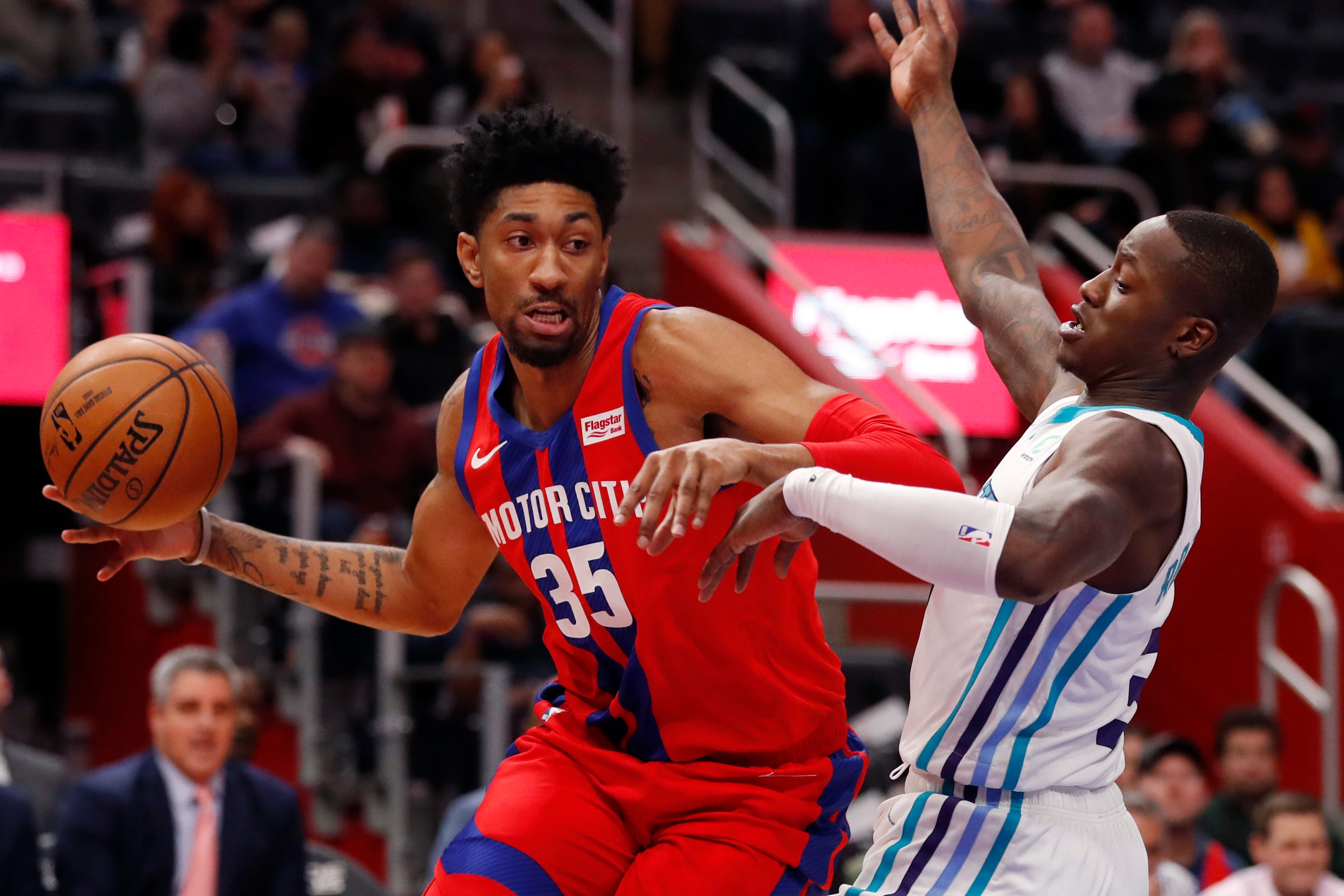 Pistons forward Christian Wood looks to pass as Hornets guard Terry Rozier defends.