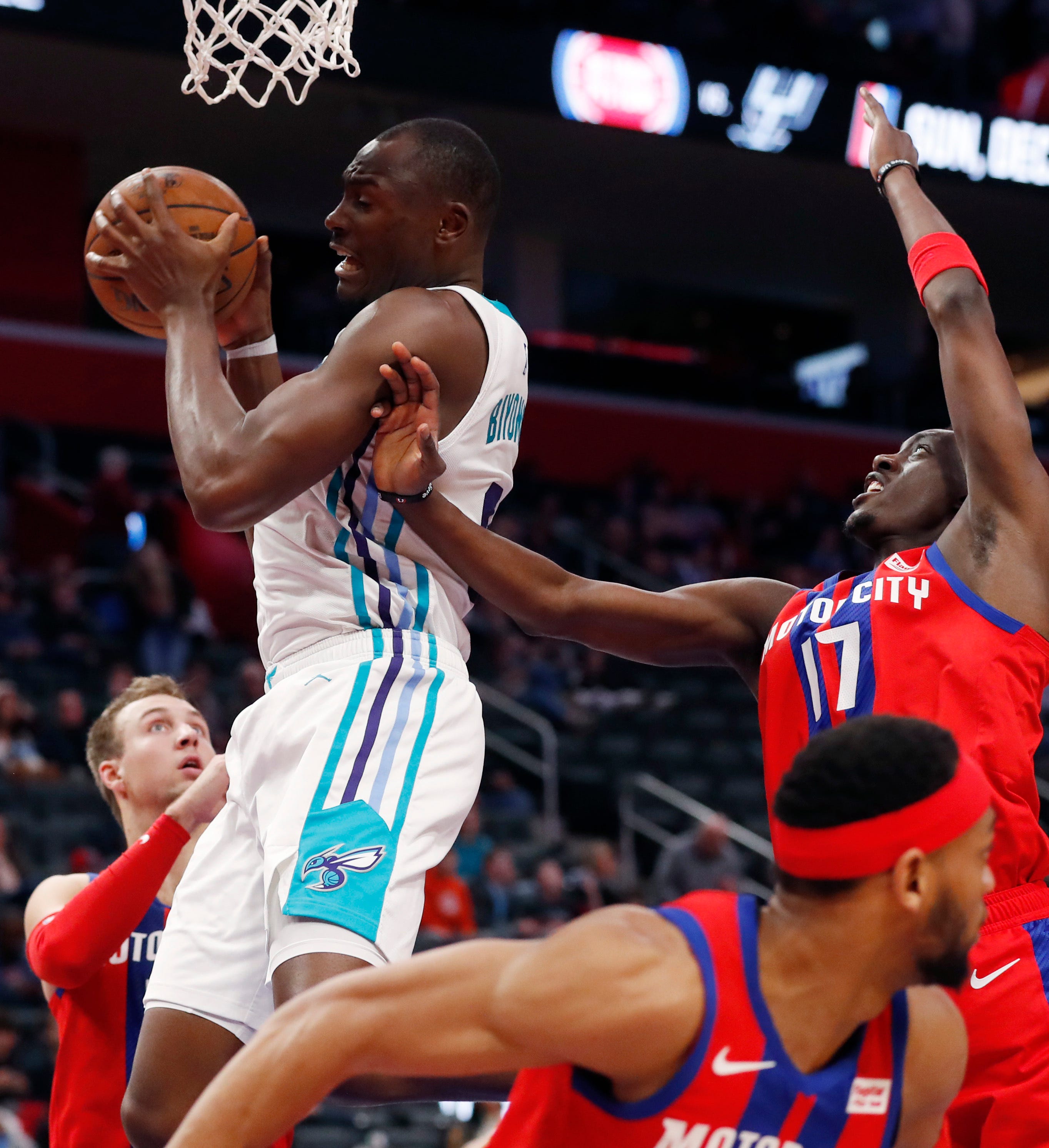Hornets center Bismack Biyombo, top left, grabs a rebound next to Pistons guard Tony Snell.