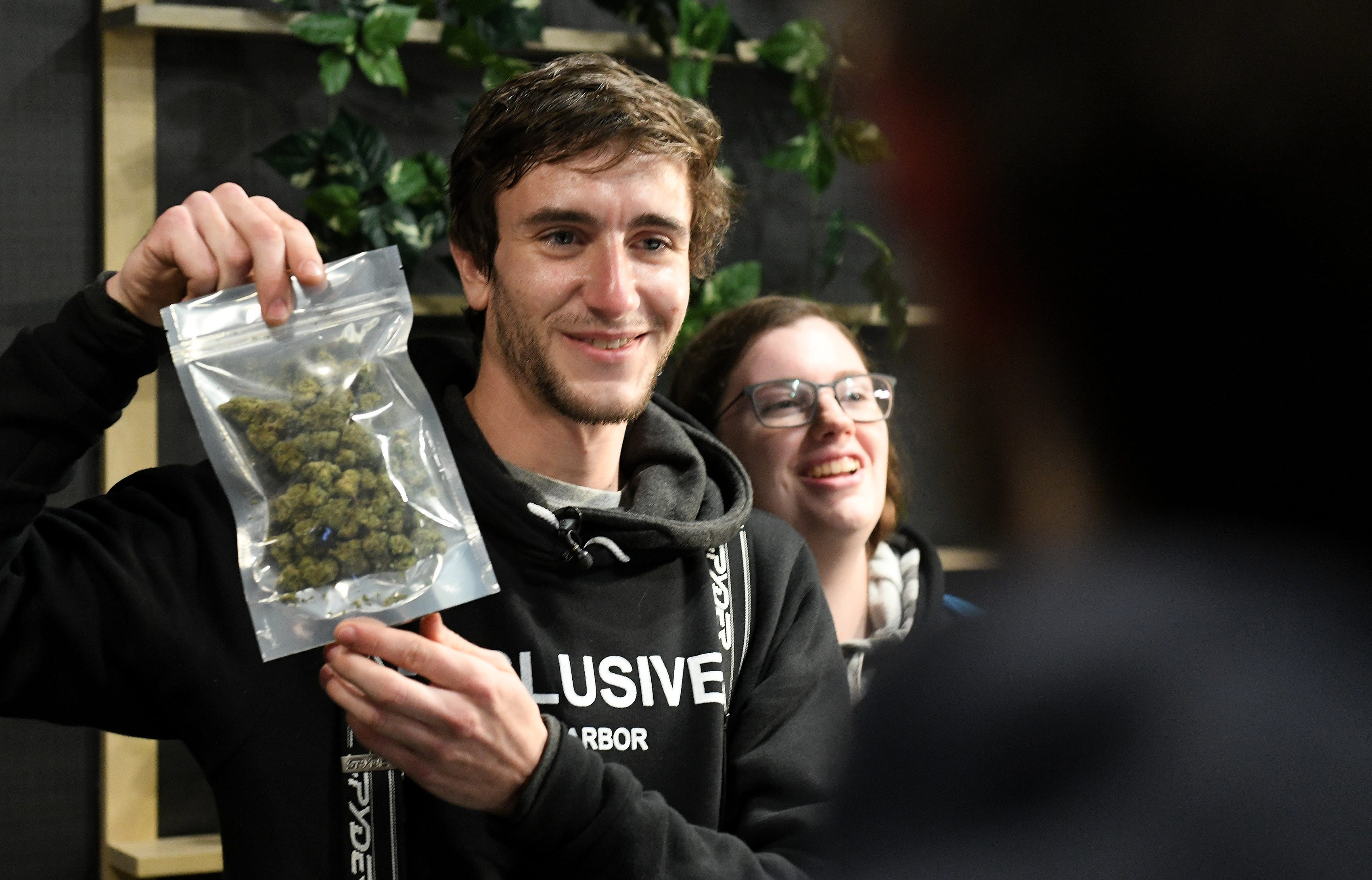 Kelly Savage, 25, of Ohio, left, with Karessa Elsberry, right, makes the first purchase of recreational marijuana at Exclusive Provisioning Center in Ann Arbor, Mich. on Dec. 1, 2019.  Savage has Type 1 diabetes and also uses marijuana socially.
(Robin Buckson / The Detroit News)