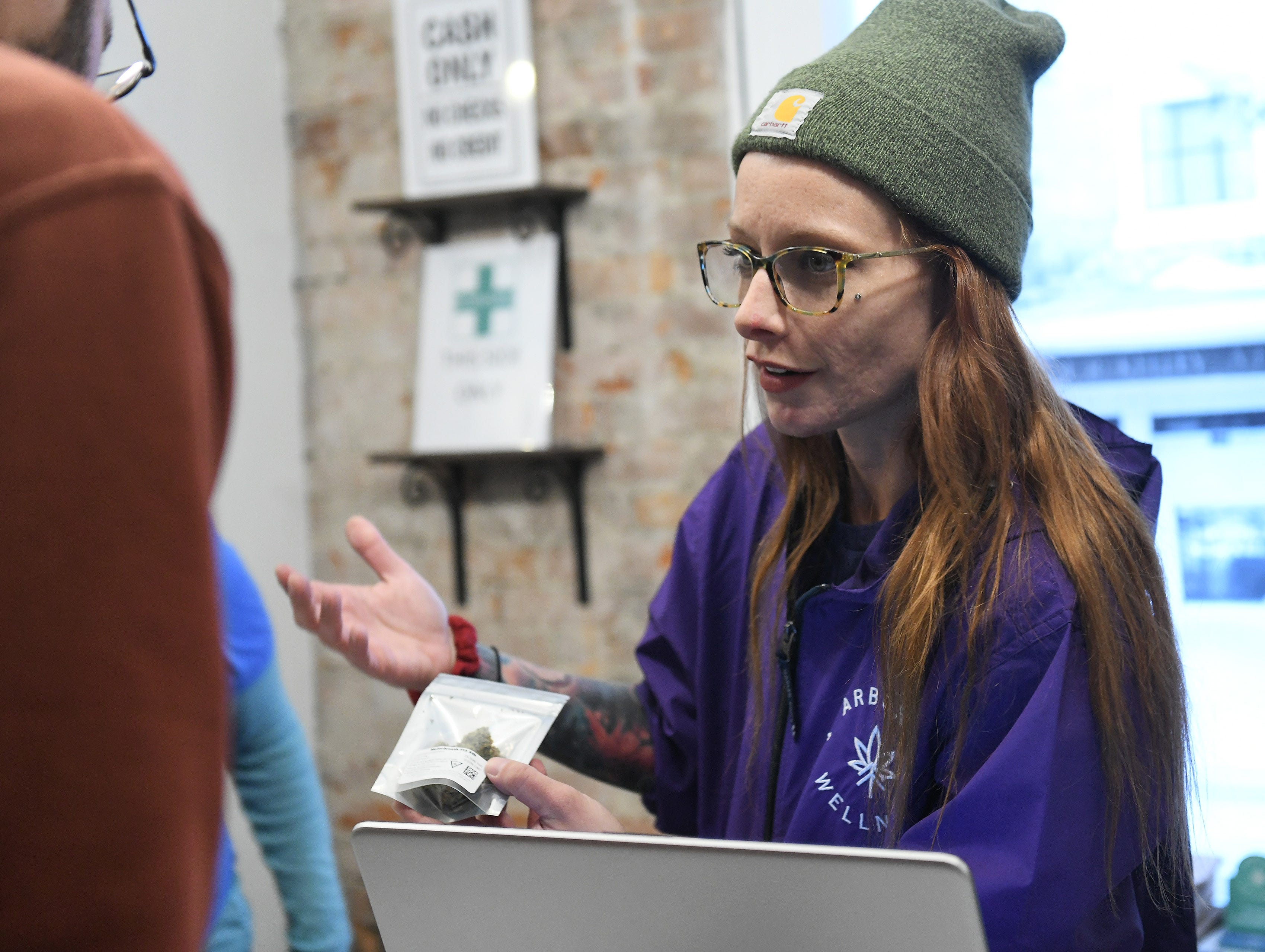 Consultant Kiersten O'Connor, right, talks about the selection of recreational marijuana at Arbors Wellness in Ann Arbor, Mich.