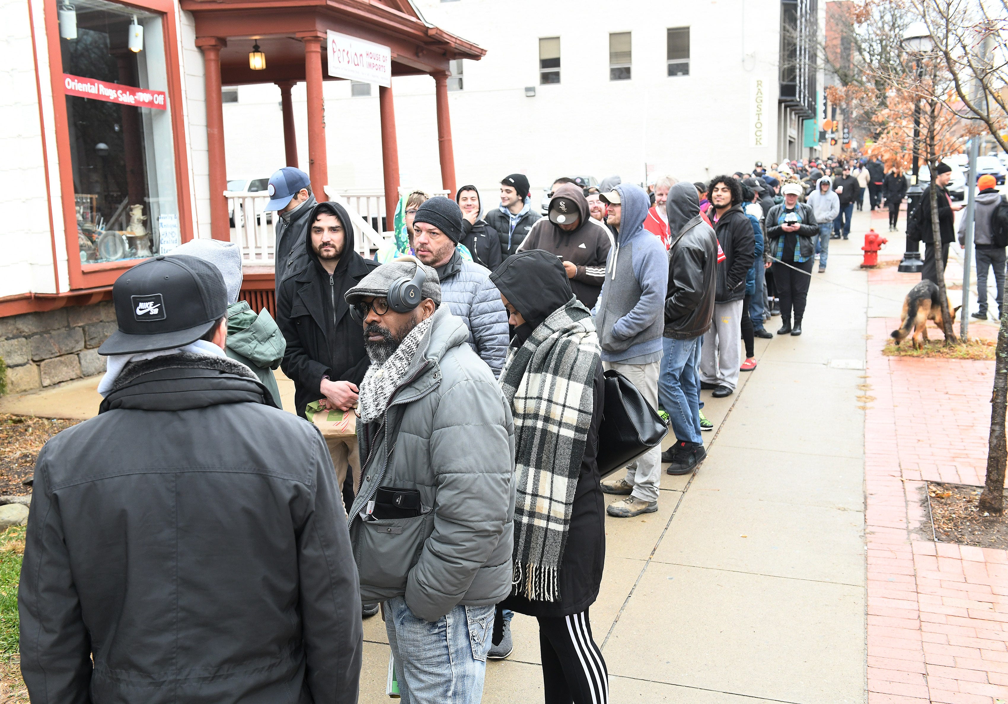 A long line stretches along a block from Arbors Wellness in Ann Arbor, Mich. on Dec. 1, 2019.  This is the first day of legal recreational marijuana sales in Michigan.