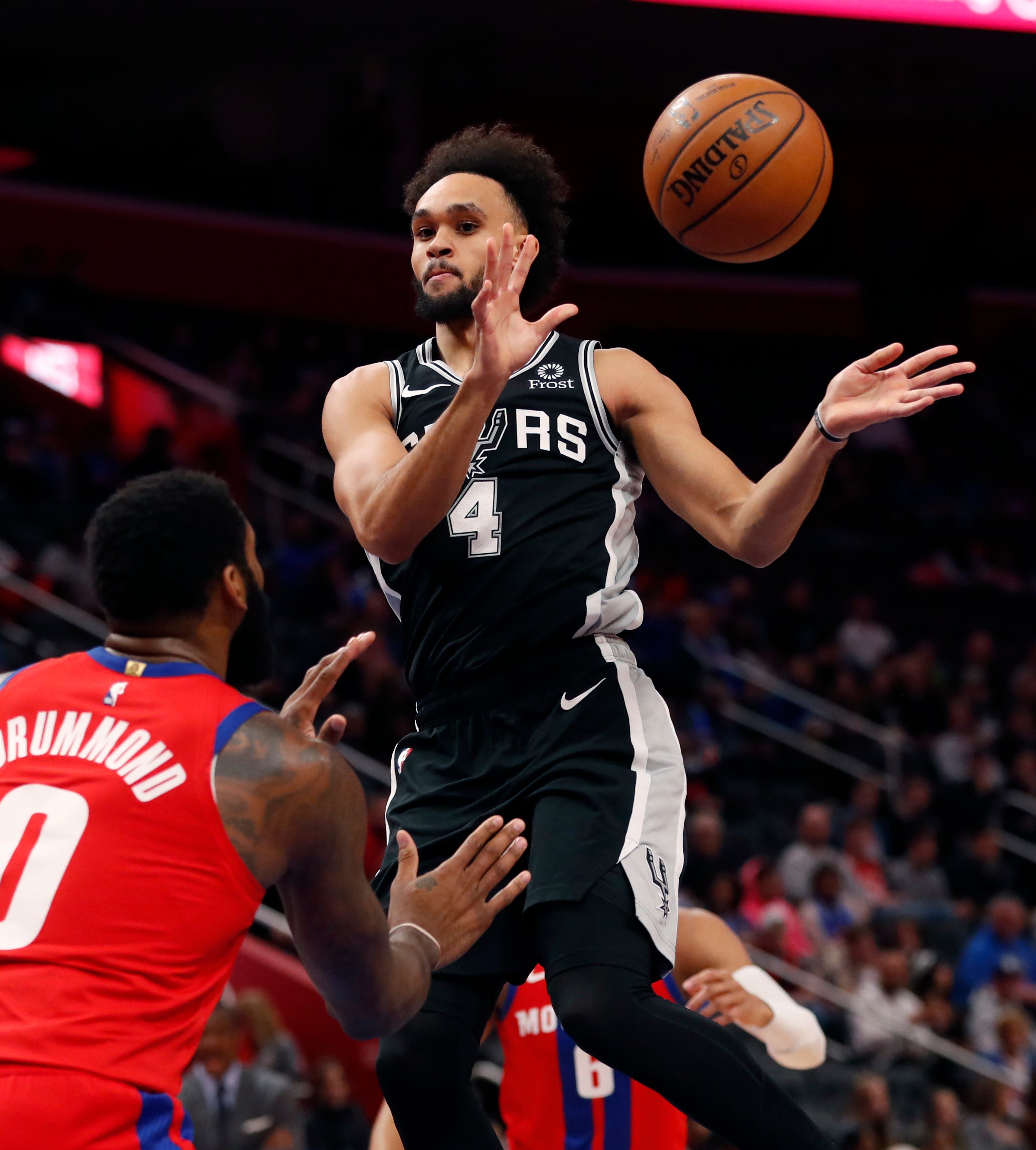 San Antonio Spurs guard Derrick White passes in front of Detroit Pistons center Andre Drummond during the first half.