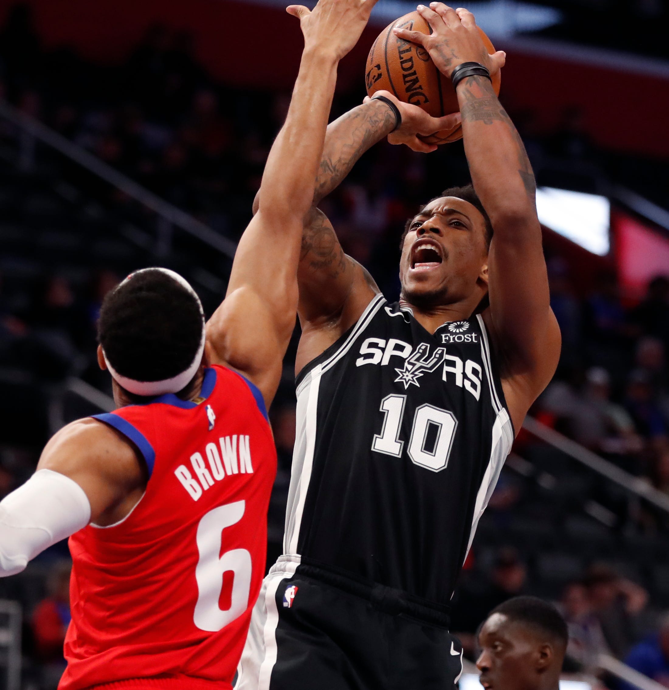 San Antonio Spurs guard DeMar DeRozan (10) shoots as Detroit Pistons guard Bruce Brown (6) defends during the first half.