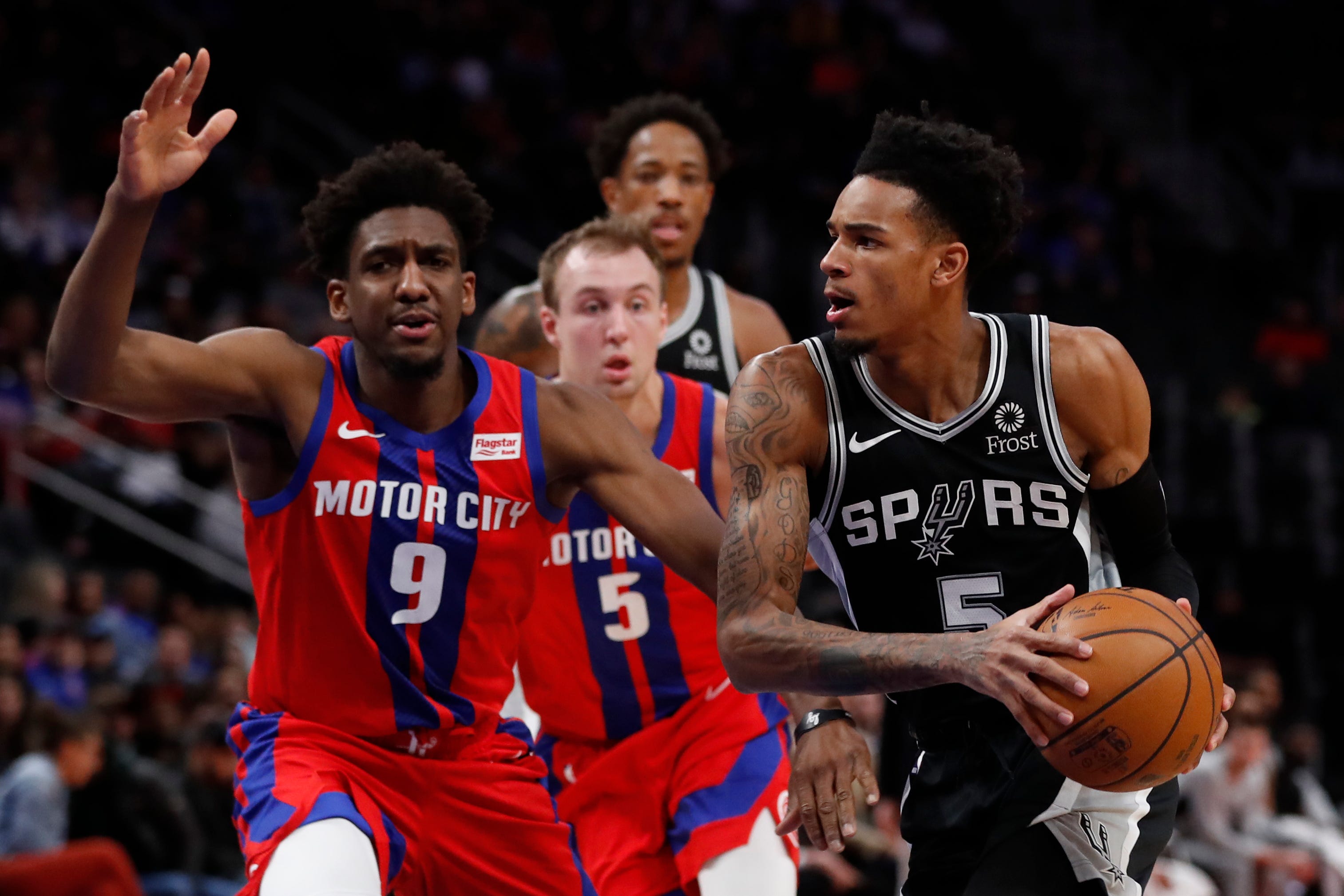 San Antonio Spurs guard Dejounte Murray (5) is defended by Detroit Pistons guard Langston Galloway (9) and guard Luke Kennard (5) during the first half.