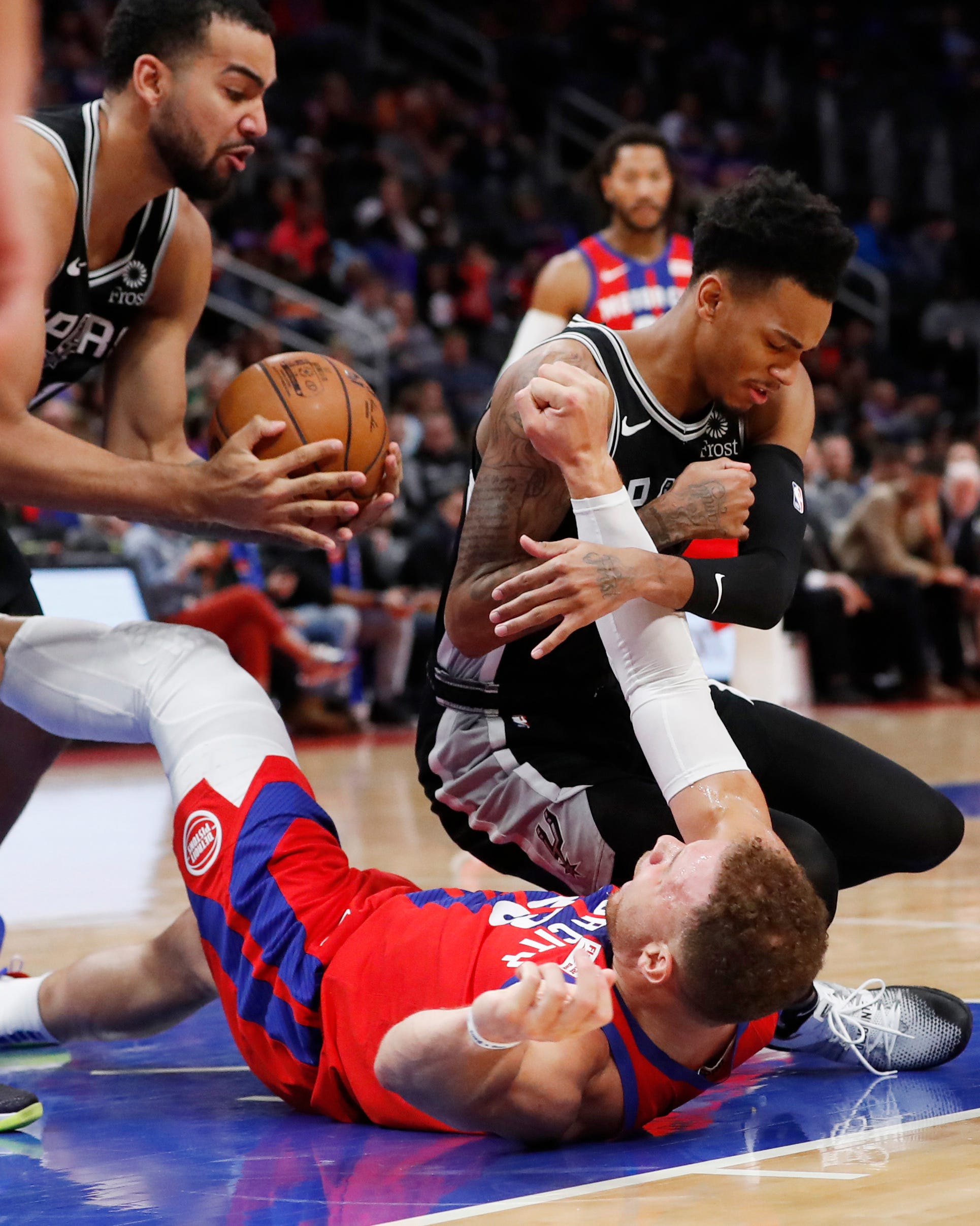 San Antonio Spurs guard Dejounte Murray, top right, knocks the ball away from Detroit Pistons forward Blake Griffin to teammate forward Trey Lyles, left, during the second half.