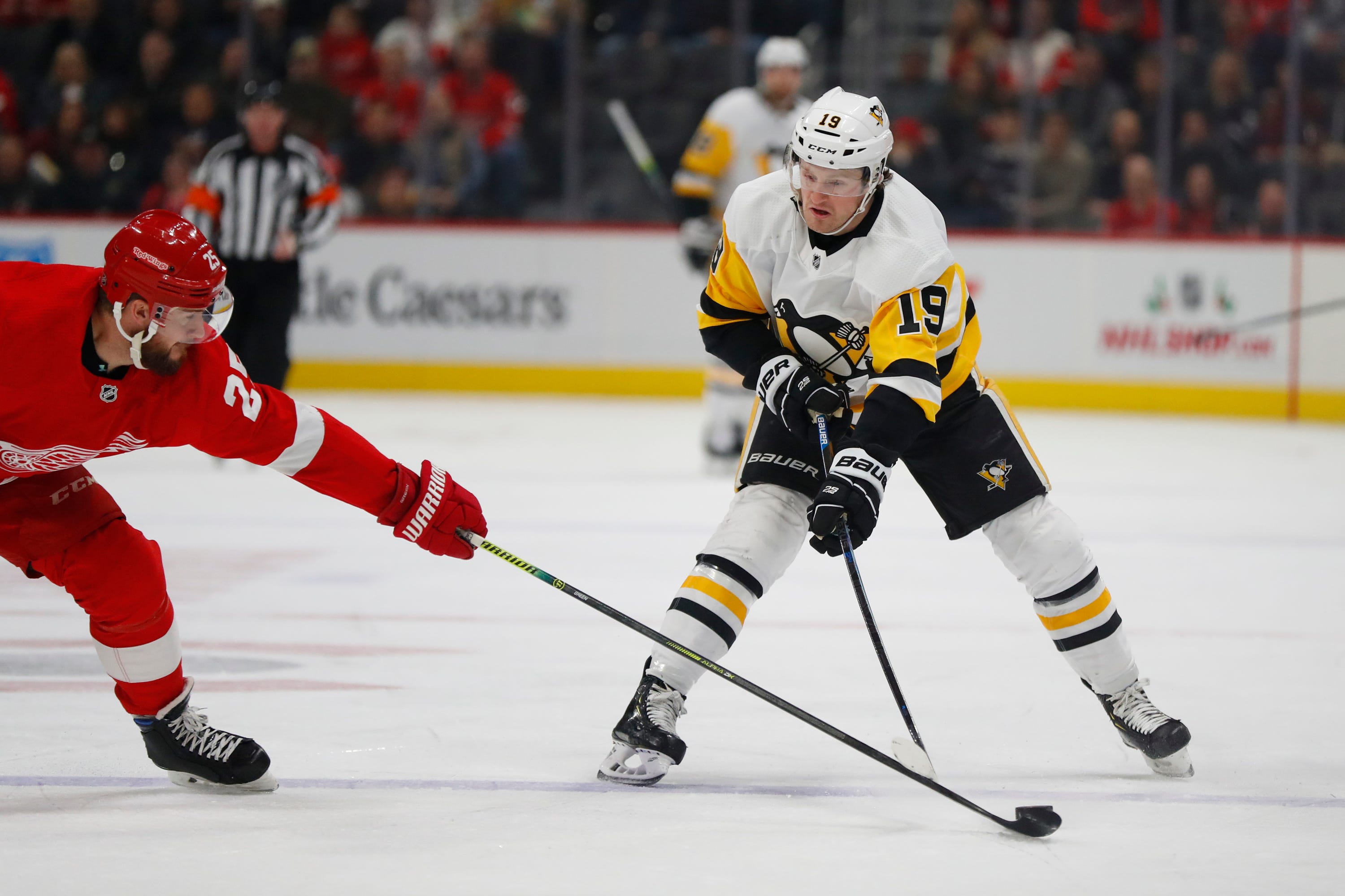 Detroit Red Wings defenseman Mike Green (25) pokes the puck from Pittsburgh Penguins center Jared McCann (19) in the first period.