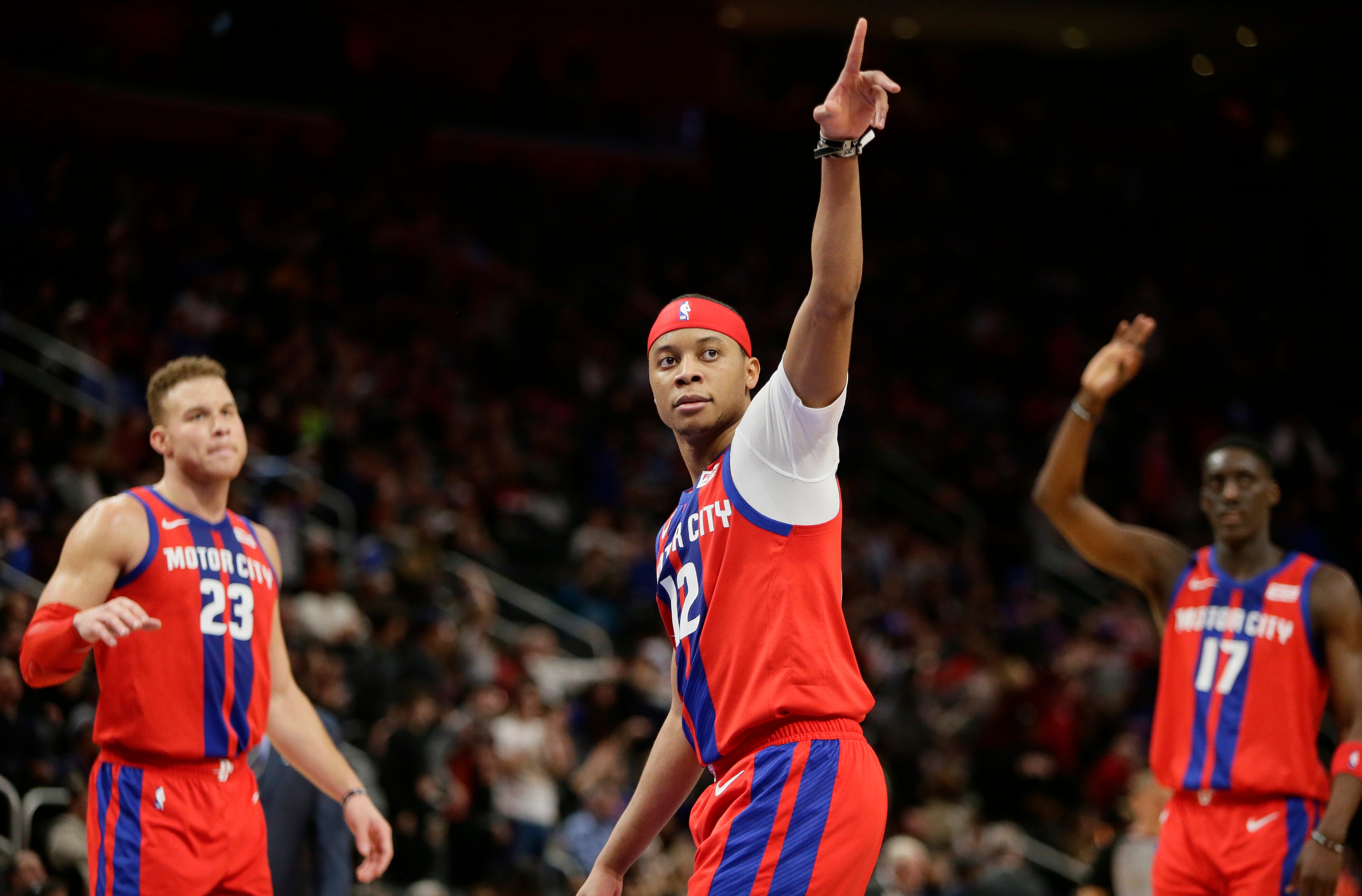 Detroit Pistons guard Tim Frazier (12) points to the crowd as he celebrates with forward Blake Griffin (23) and guard Tony Snell (17) late in the fourth quarter.