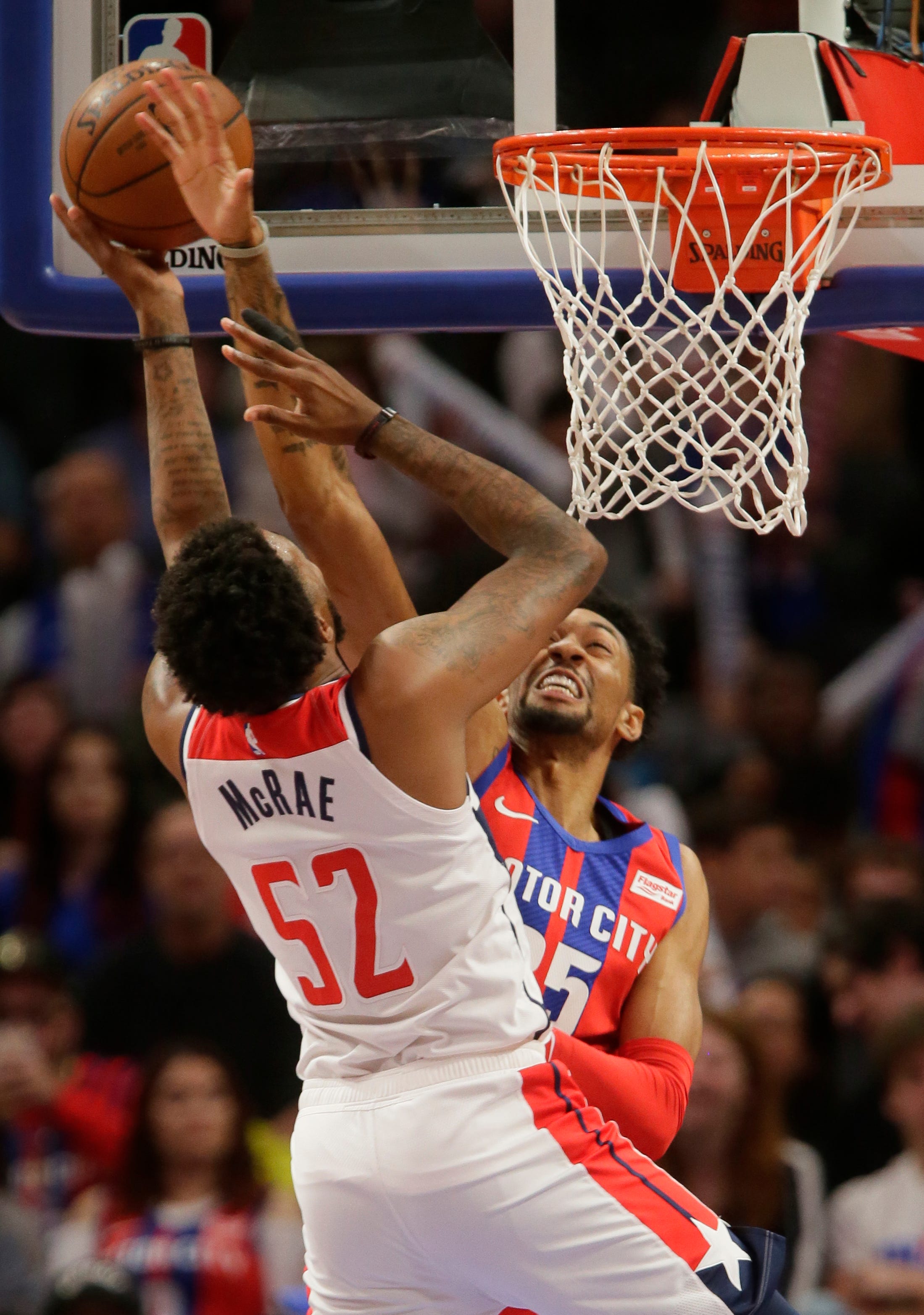 Detroit Pistons forward Christian Wood, right, defends against a shot by Washington Wizards guard Jordan McRae (52) during the first half.
