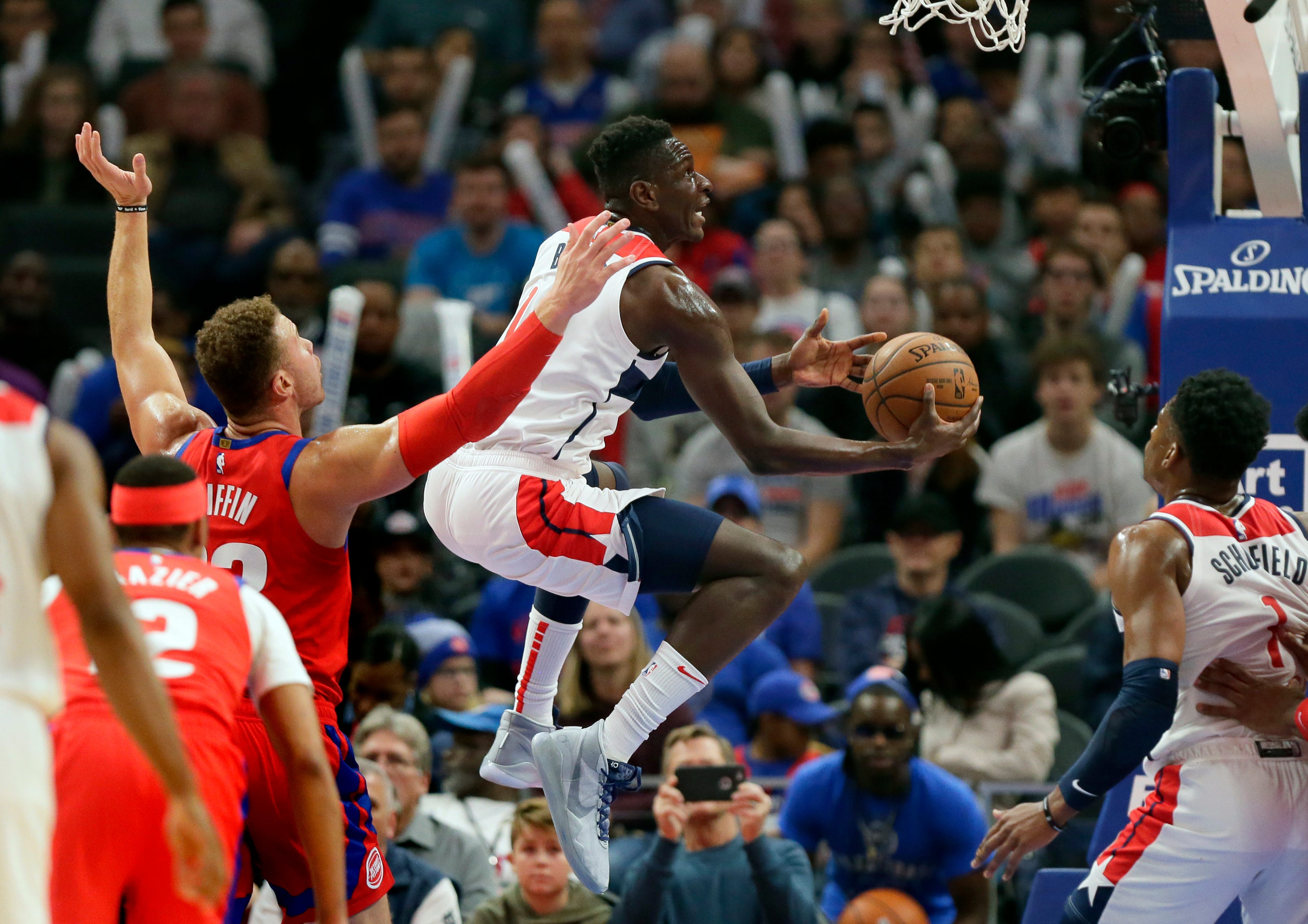 Washington Wizards guard Isaac Bonga, center, goes to the basket past Detroit Pistons forward Blake Griffin (23) during the first half.