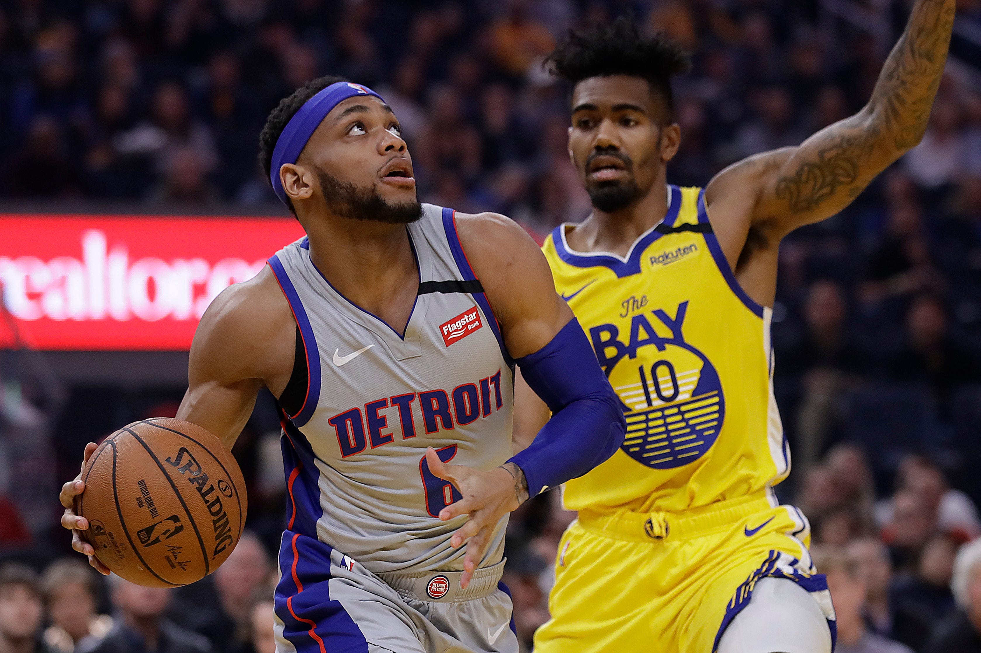 Detroit Pistons' Bruce Brown, left, looks to shoot against Golden State Warriors' Jacob Evans (10) during the first half.