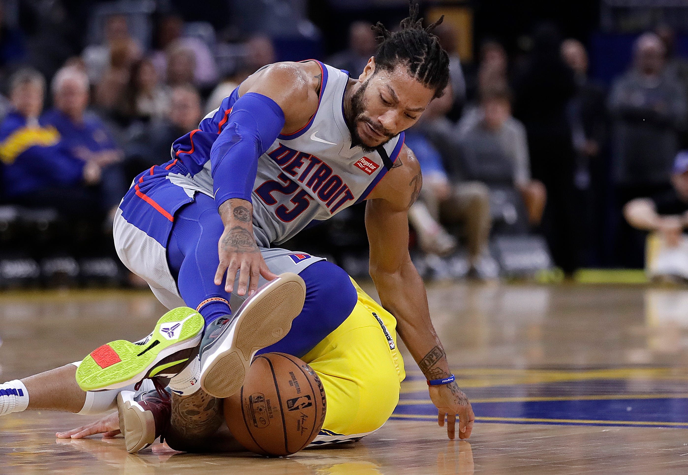 Detroit Pistons' Derrick Rose, top, looks for the ball after colliding with Golden State Warriors' Ky Bowman in the second half.