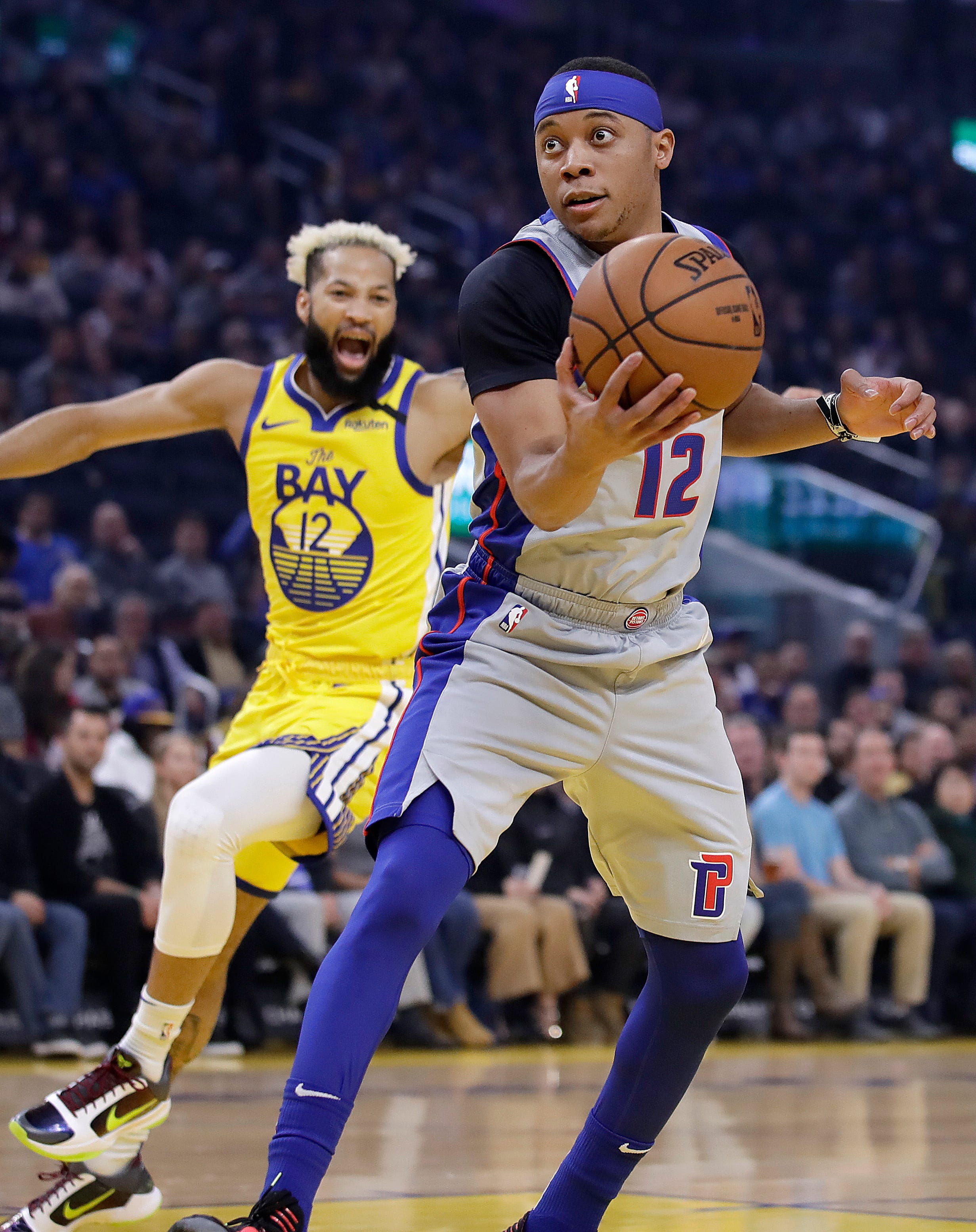 Detroit Pistons' Tim Frazier, right, looks to shoot past Golden State Warriors' Ky Bowman during the first half.