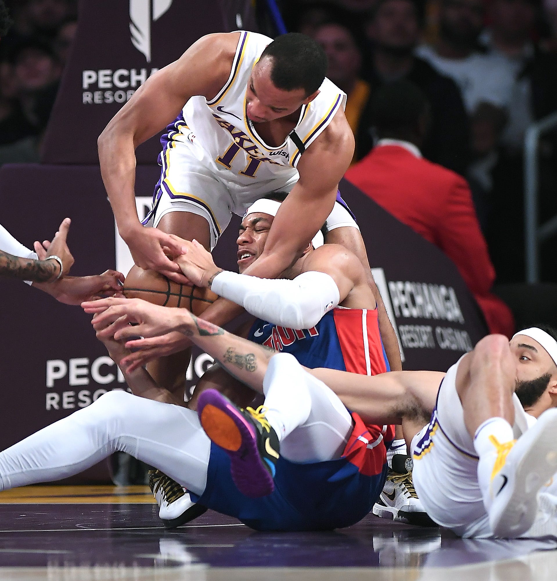 Los Angeles Lakers' Avery Bradley (11) fouls Detroit Pistons' Bruce Brown as JaVale McGee tries to help on defense as they battle for a loose ball in the second quarter.