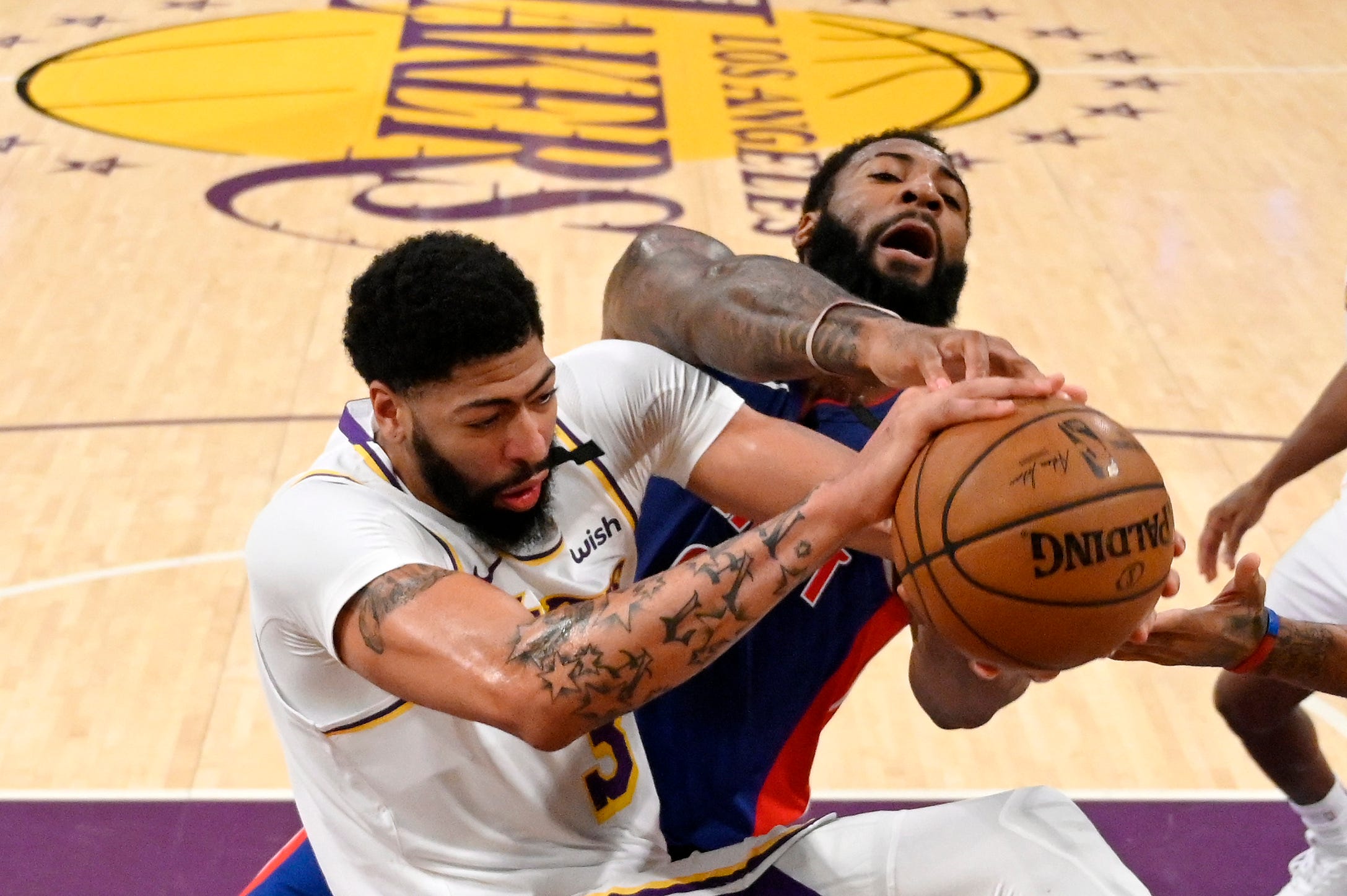 Los Angeles Lakers forward Anthony Davis, left, and Detroit Pistons center Andre Drummond grapple for the ball during the first half.