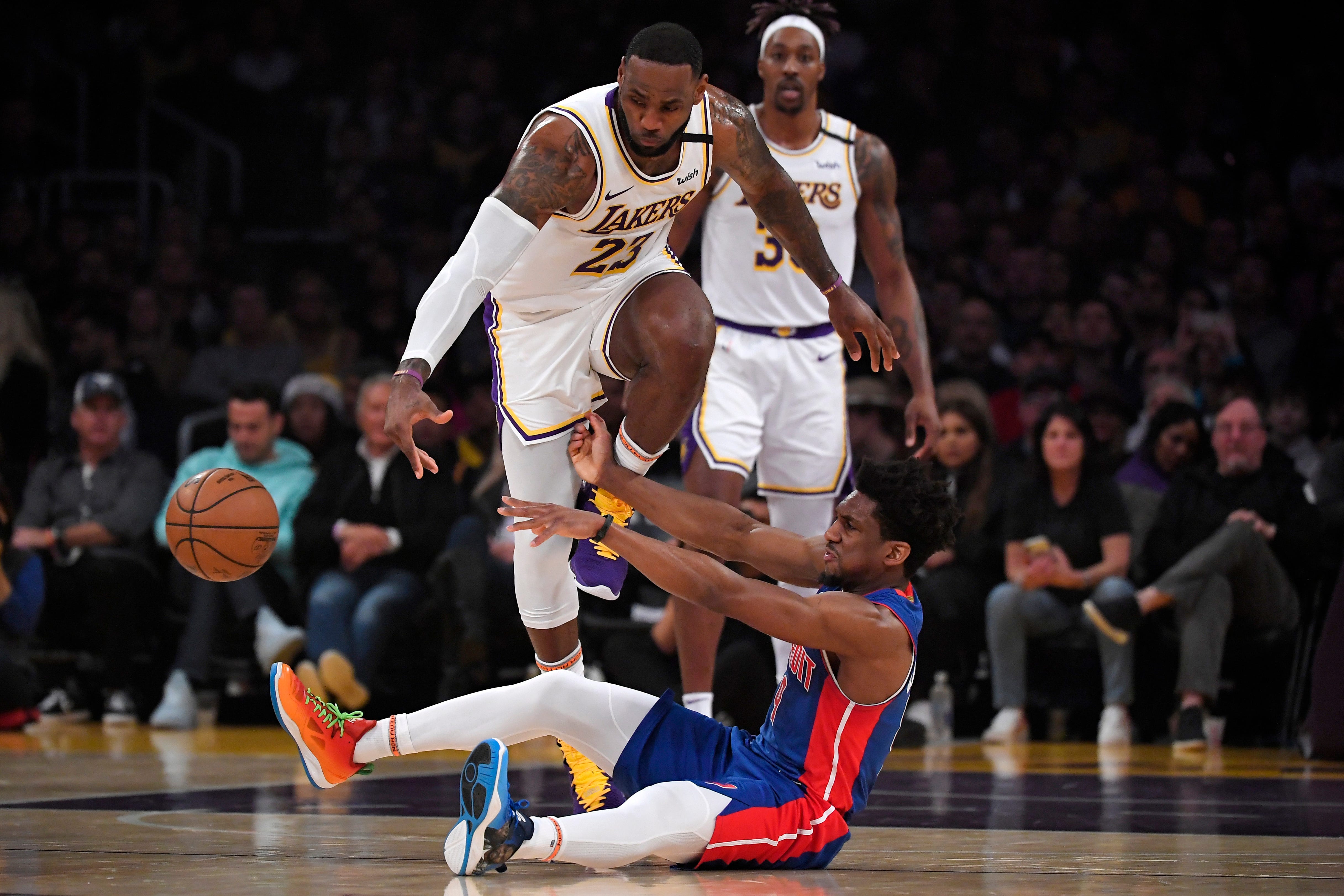 Detroit Pistons guard Langston Galloway, below, passes the ball from the floor as Los Angeles Lakers forward LeBron James, upper left, reaches for it and center Dwight Howard looks on during the first half.