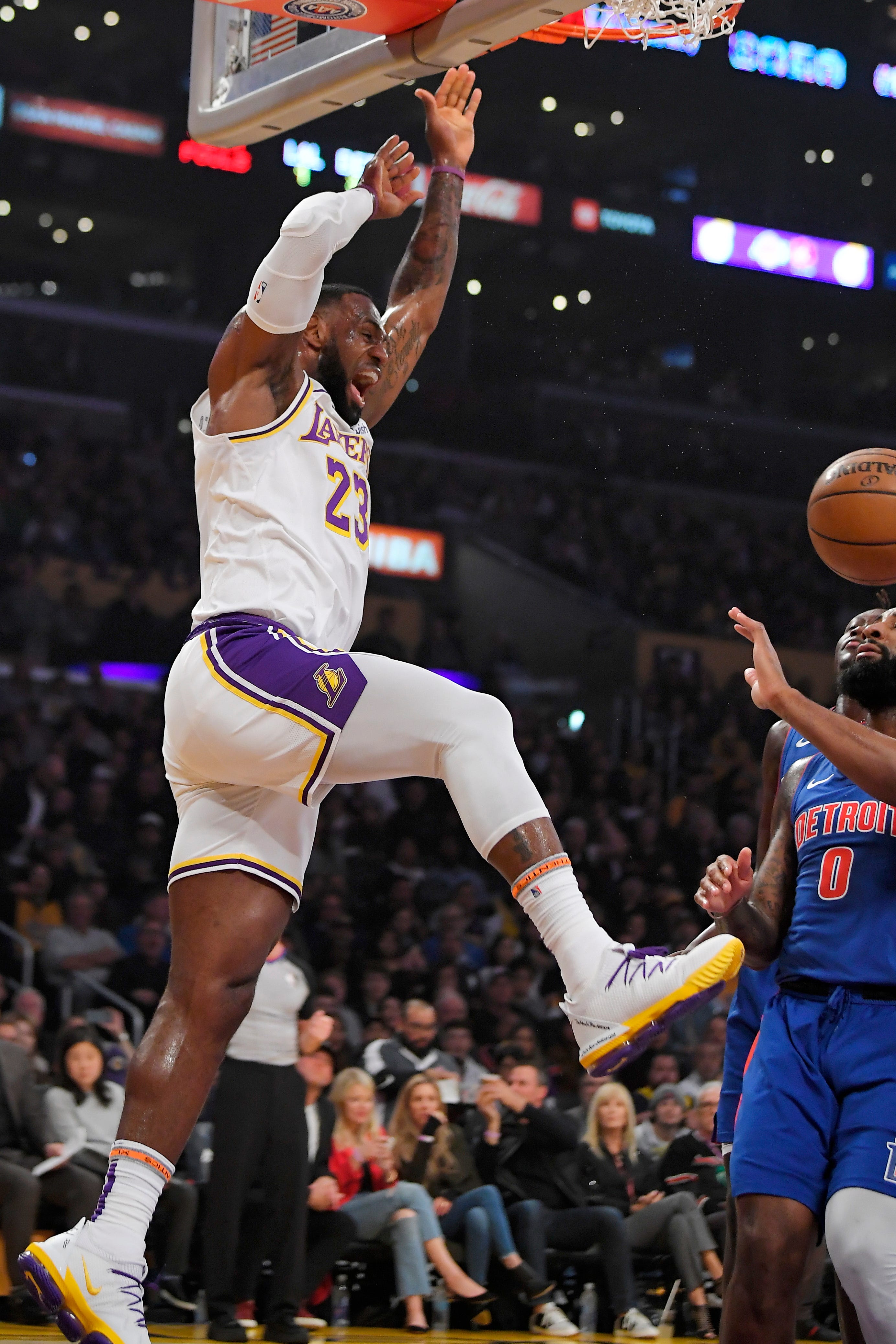 Los Angeles Lakers forward LeBron James, left, dunks as Detroit Pistons center Andre Drummond watches during the first half.