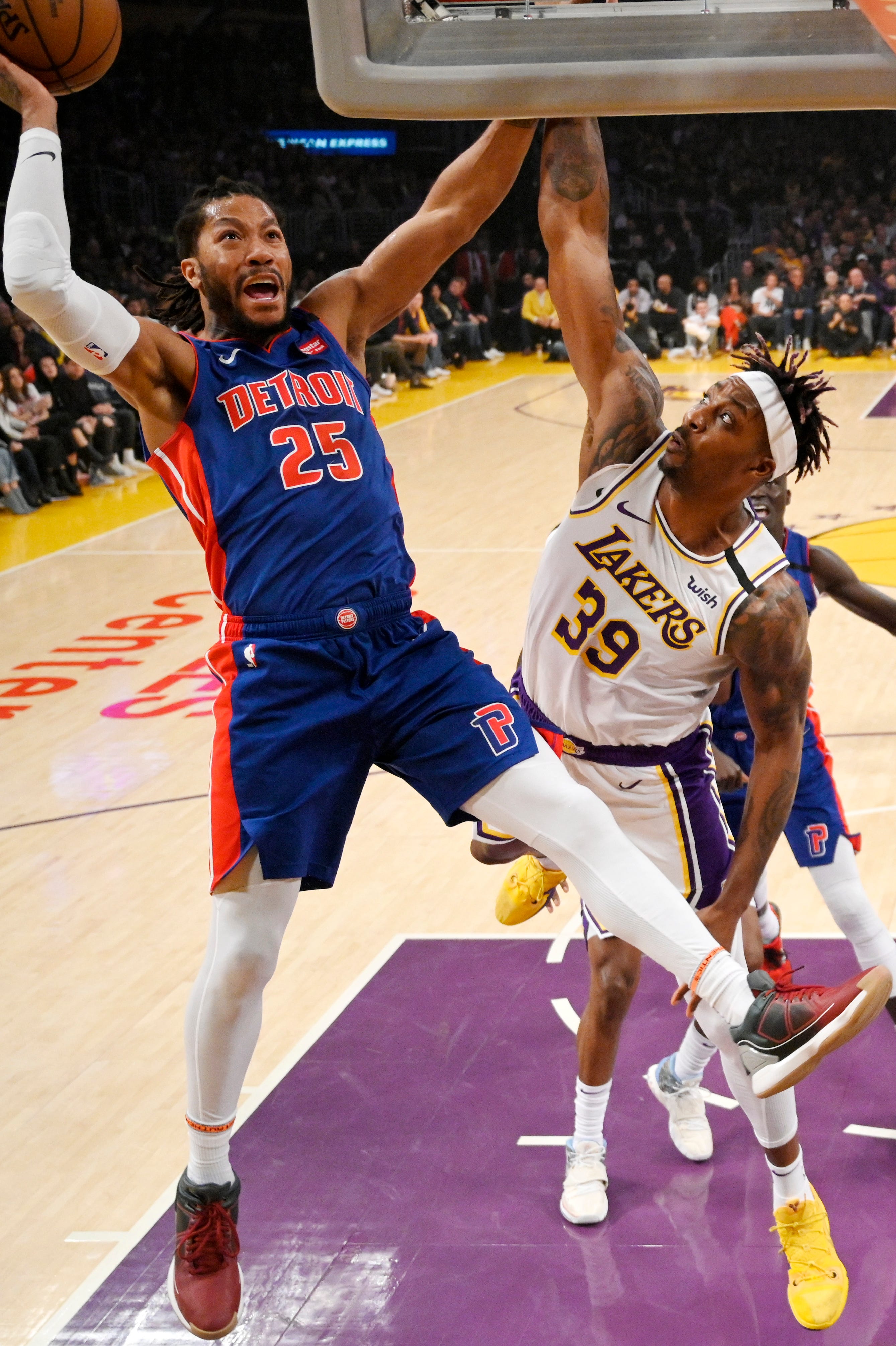 Detroit Pistons guard Derrick Rose, left, shoots as Los Angeles Lakers center Dwight Howard defends during the first half.