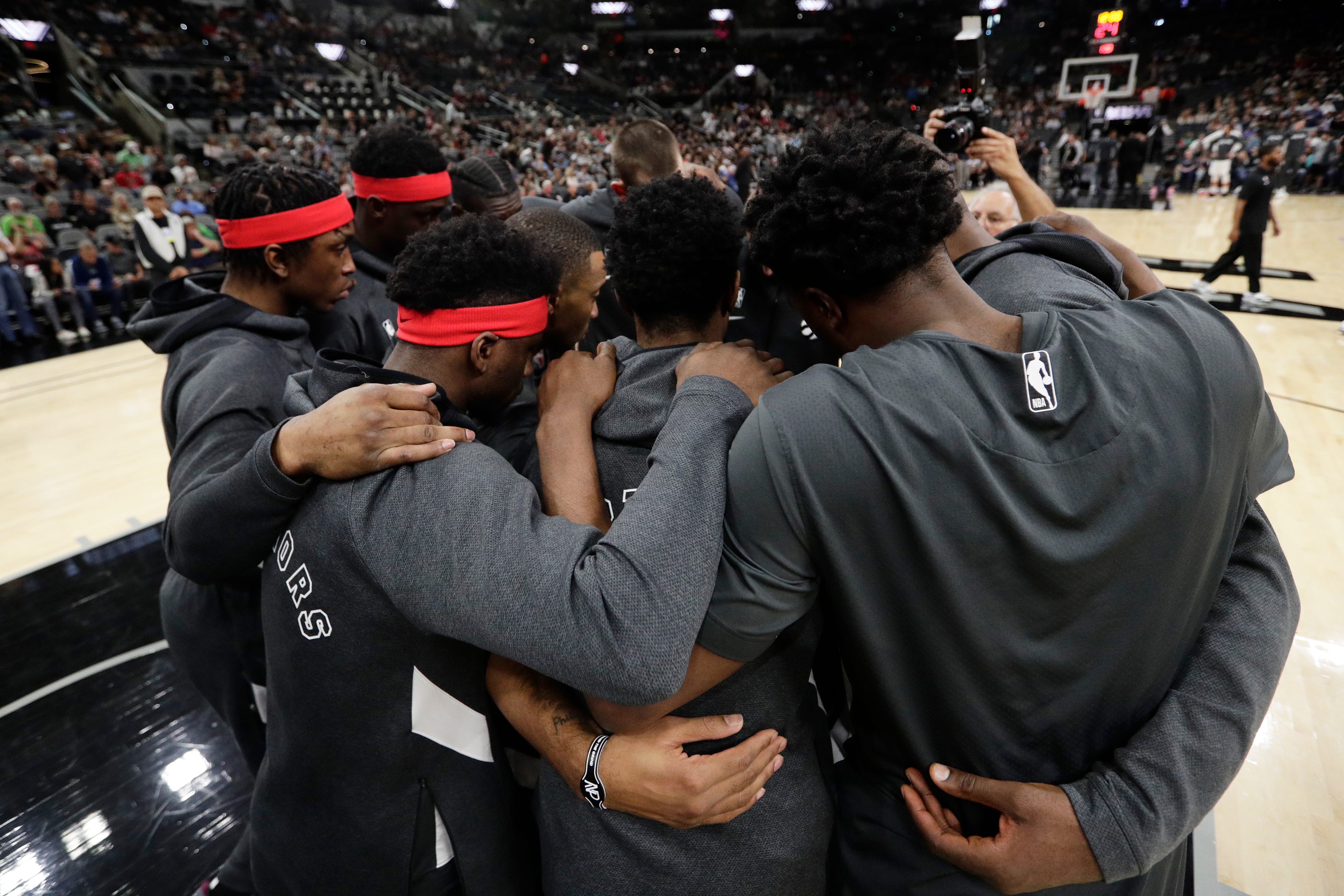 Toronto Raptors players huddle together following a moment of silence for Kobe Bryant.