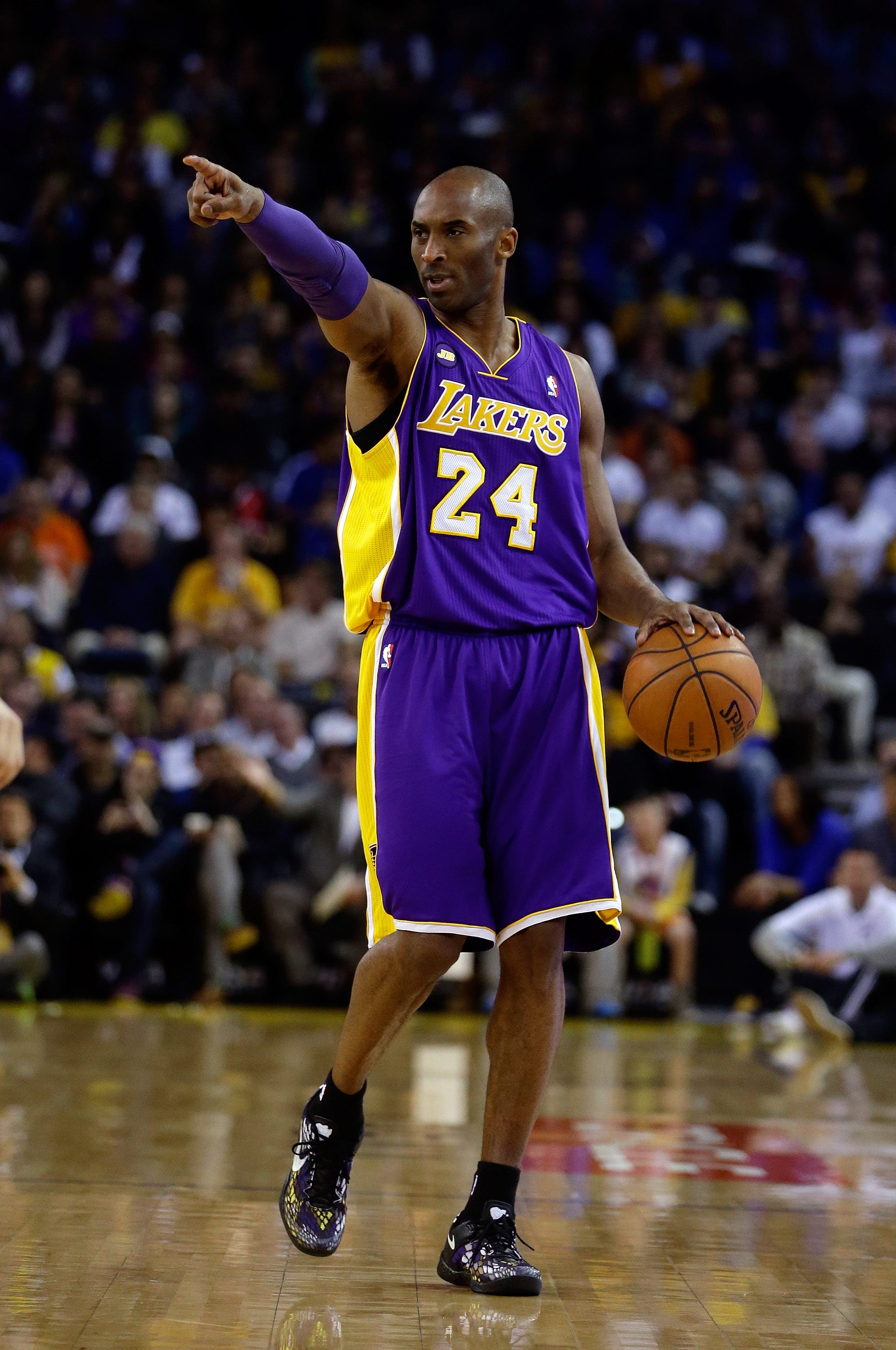 Kobe Bryant points downcourt during a game in March 2013.